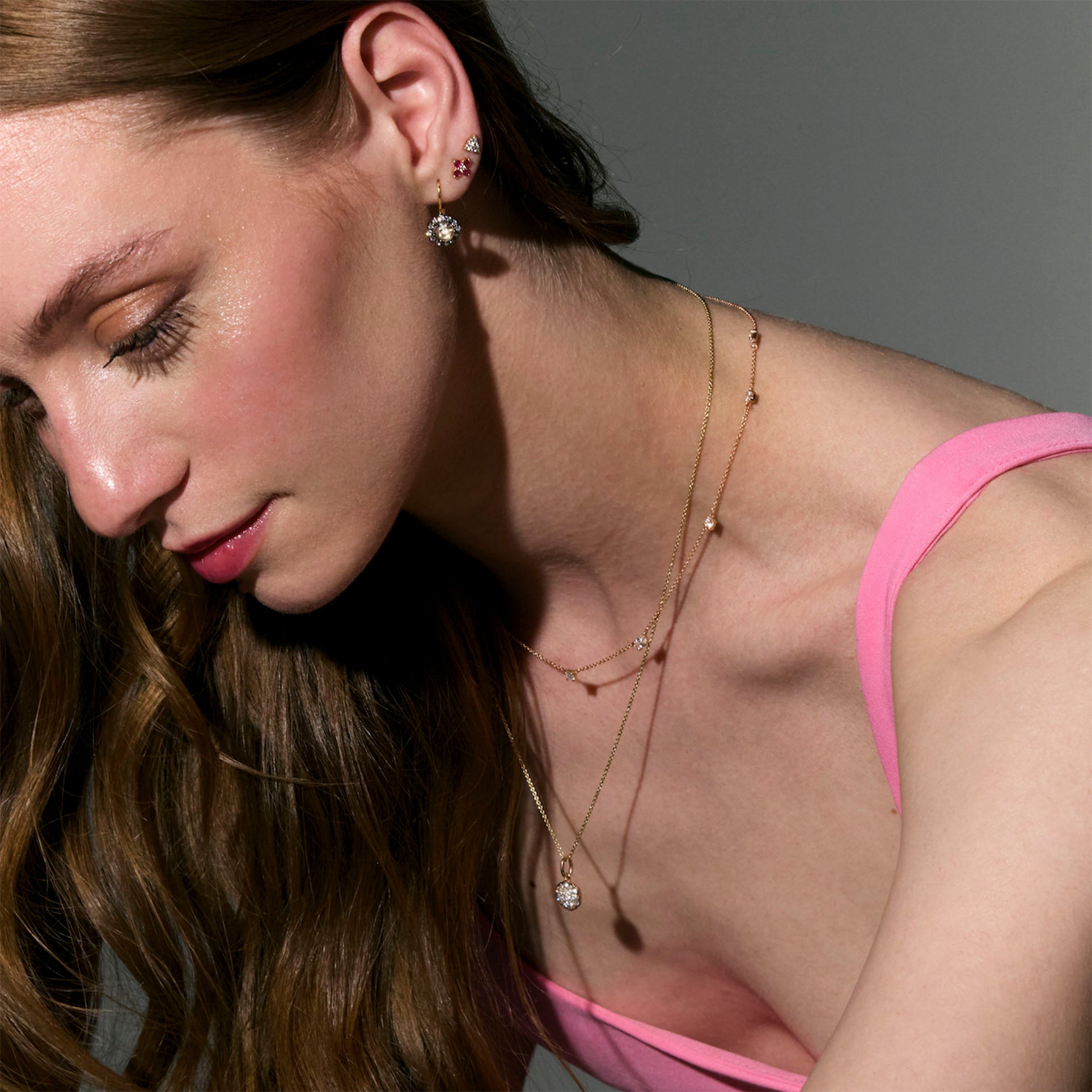 beautiful rose cut diamonds earrings, set in black rhodium 14k or 18k gold, and a dainty dot dot dot diamonds stud earring on models ear