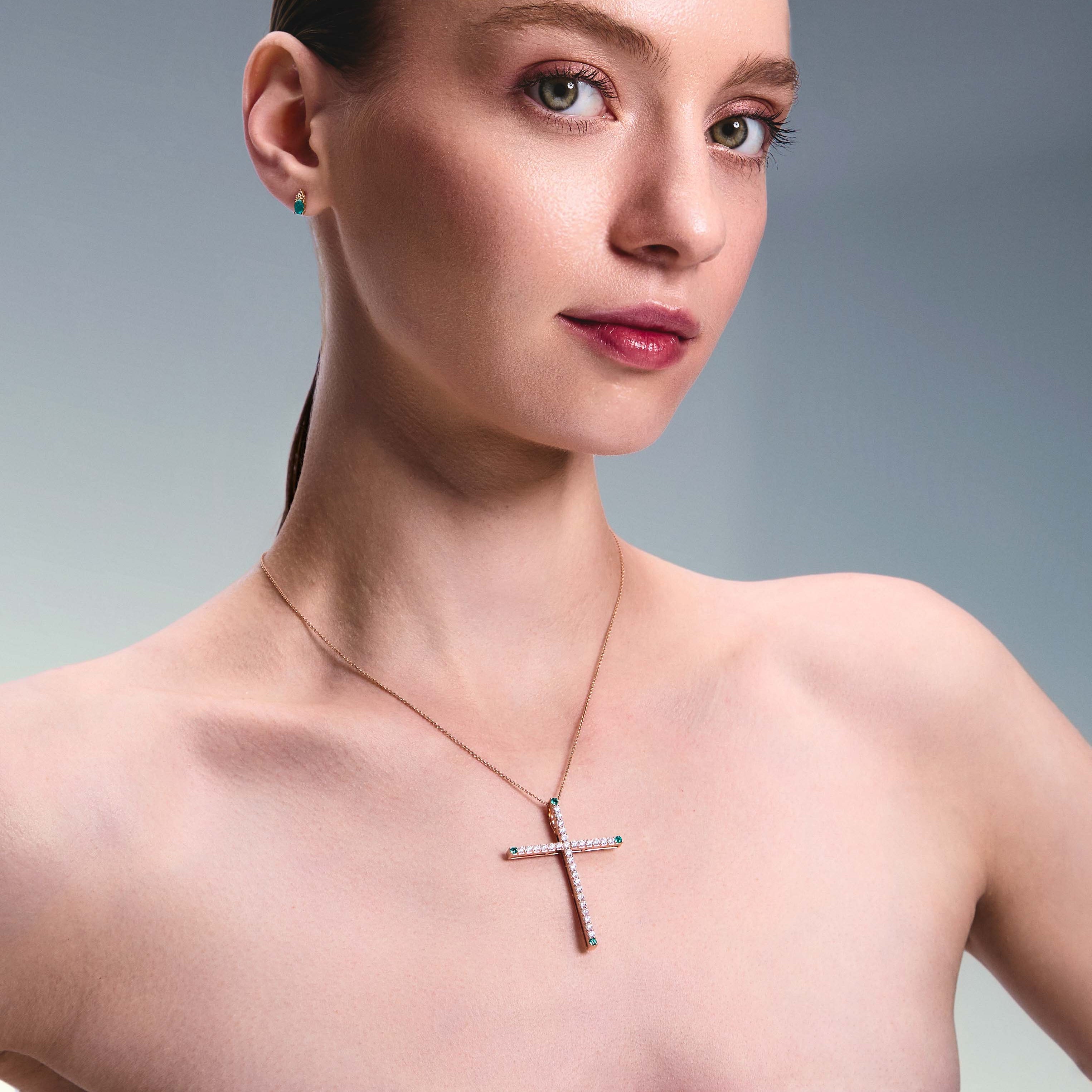 Cross pendant, elegant and bold, 5 cm long, made of rose gold, diamonds and emeralds.