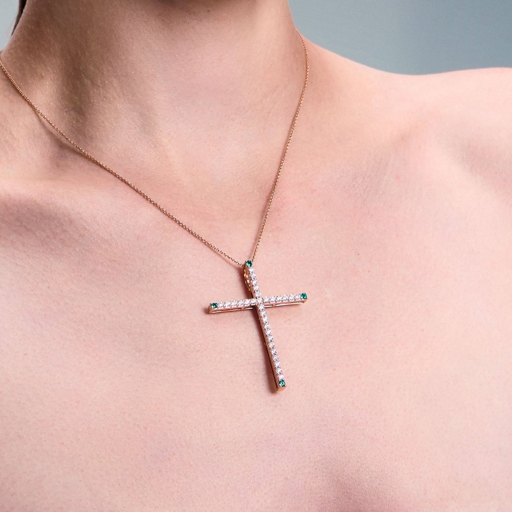 Cross pendant, elegant and bold, 5 cm long, made of rose gold, diamonds and emeralds.