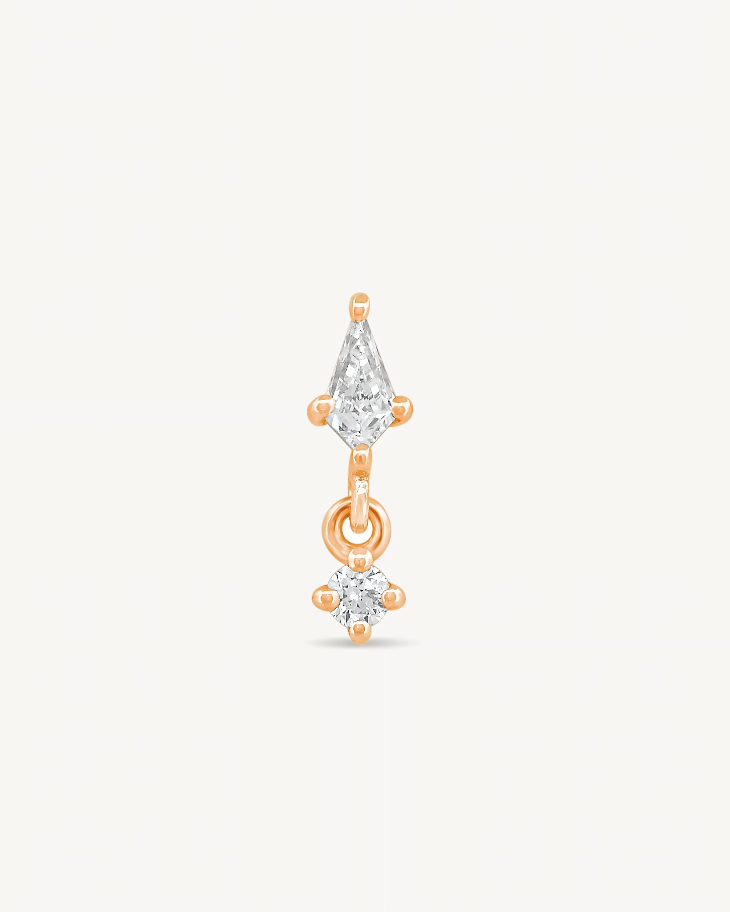 Kite and round diamonds stud earring with rose gold on a light gray background.