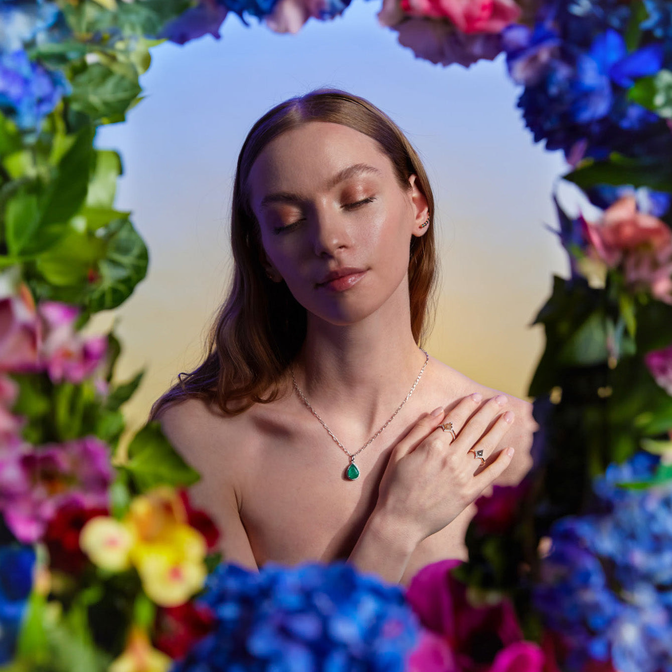 Grey and peachy salt and pepper diamond rings on hand and The Great - Emerald and diamonds pendant on model surrounded by beautiful flowers. Inele cu diamante salt and pepper gri si culoarea piersicii și pandantul The Great cu smarald si diamante pe model înconjurata de flori superbe.