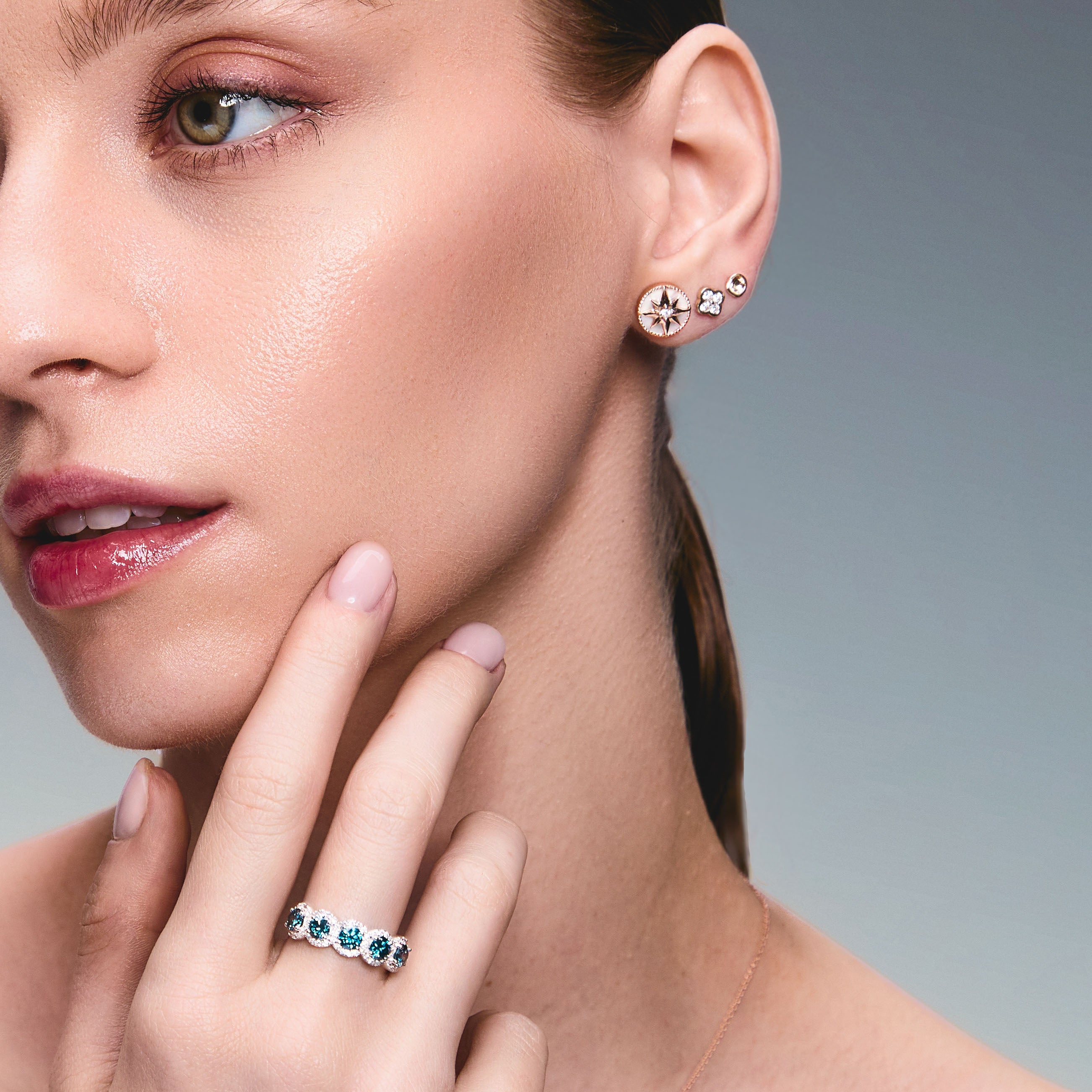 Blue Lab Diamonds and white diamonds ring in white gold, an absolutely mesmerising piece with five blue diamonds as the main stones, surrounded by white diamonds. Divine. The model is also wearing mother of pearl lodestar earrings.