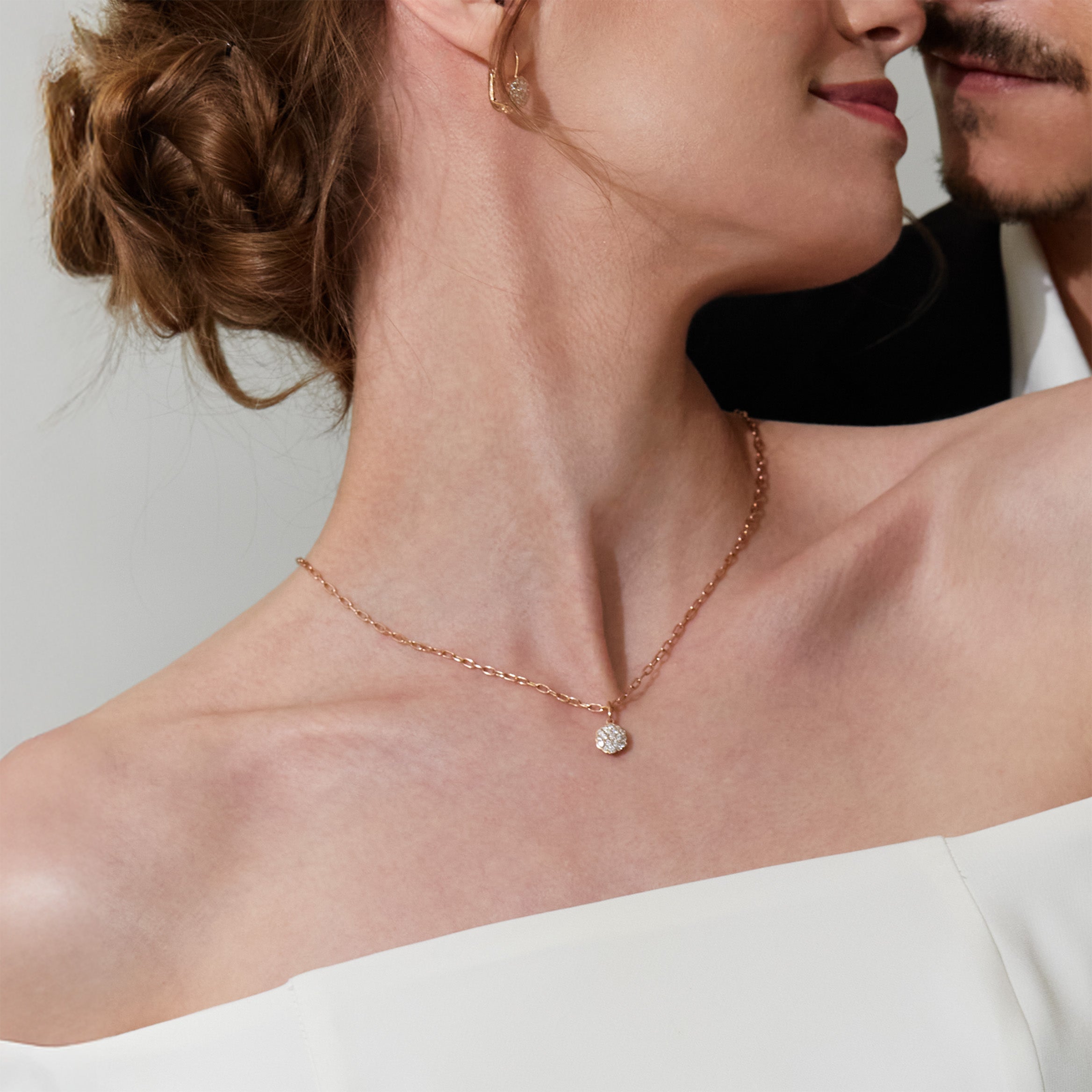 Close-up of a woman wearing a delicate necklace with a flower diamond pendant.