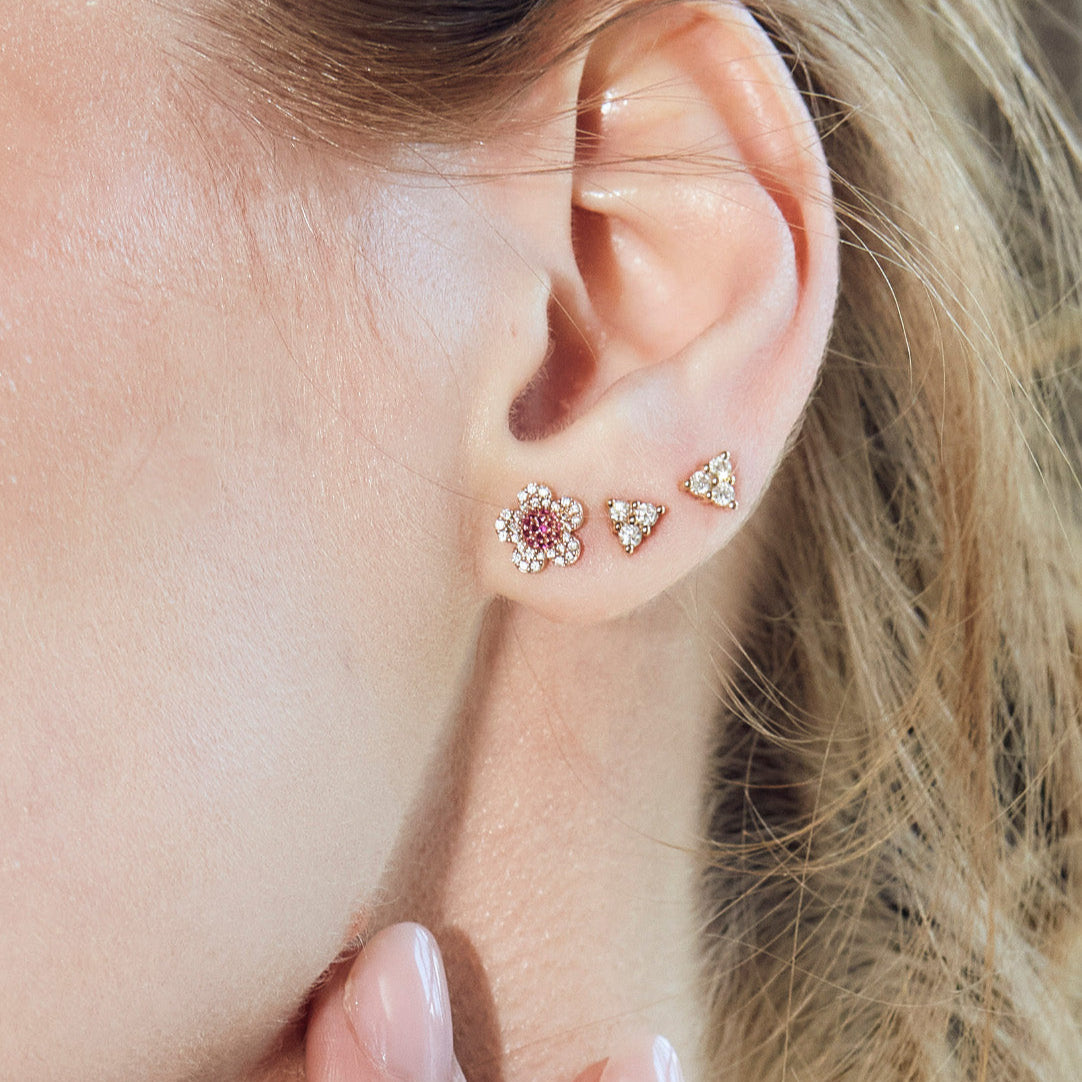beautiful blossom flower earrings on model, diamond earrings simple arranged in a game of three dots.
