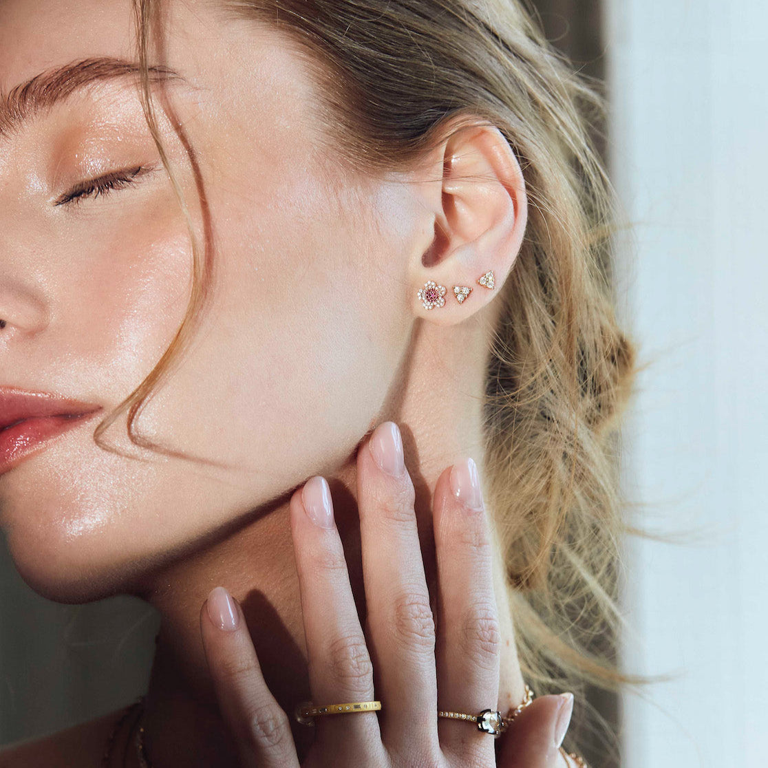 beautiful blossom flower earrings on model, diamond earrings simple arranged in a game of three dots.
