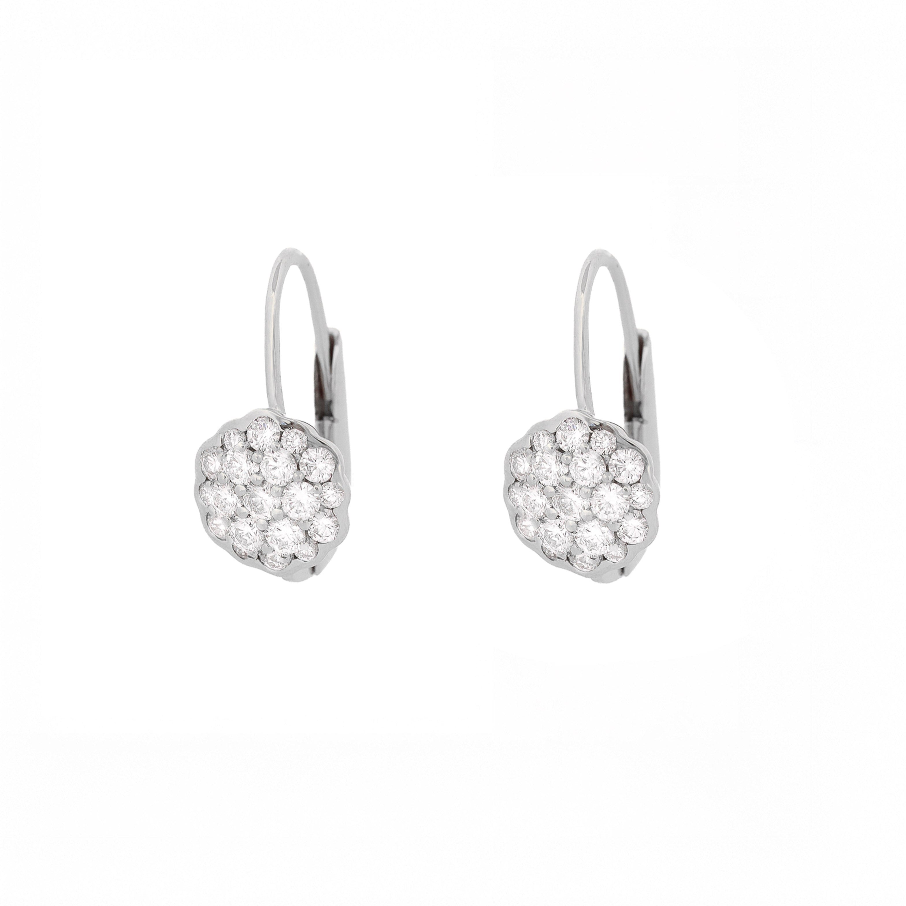 Pair of white gold earrings with a flower made of diamonds on a white background