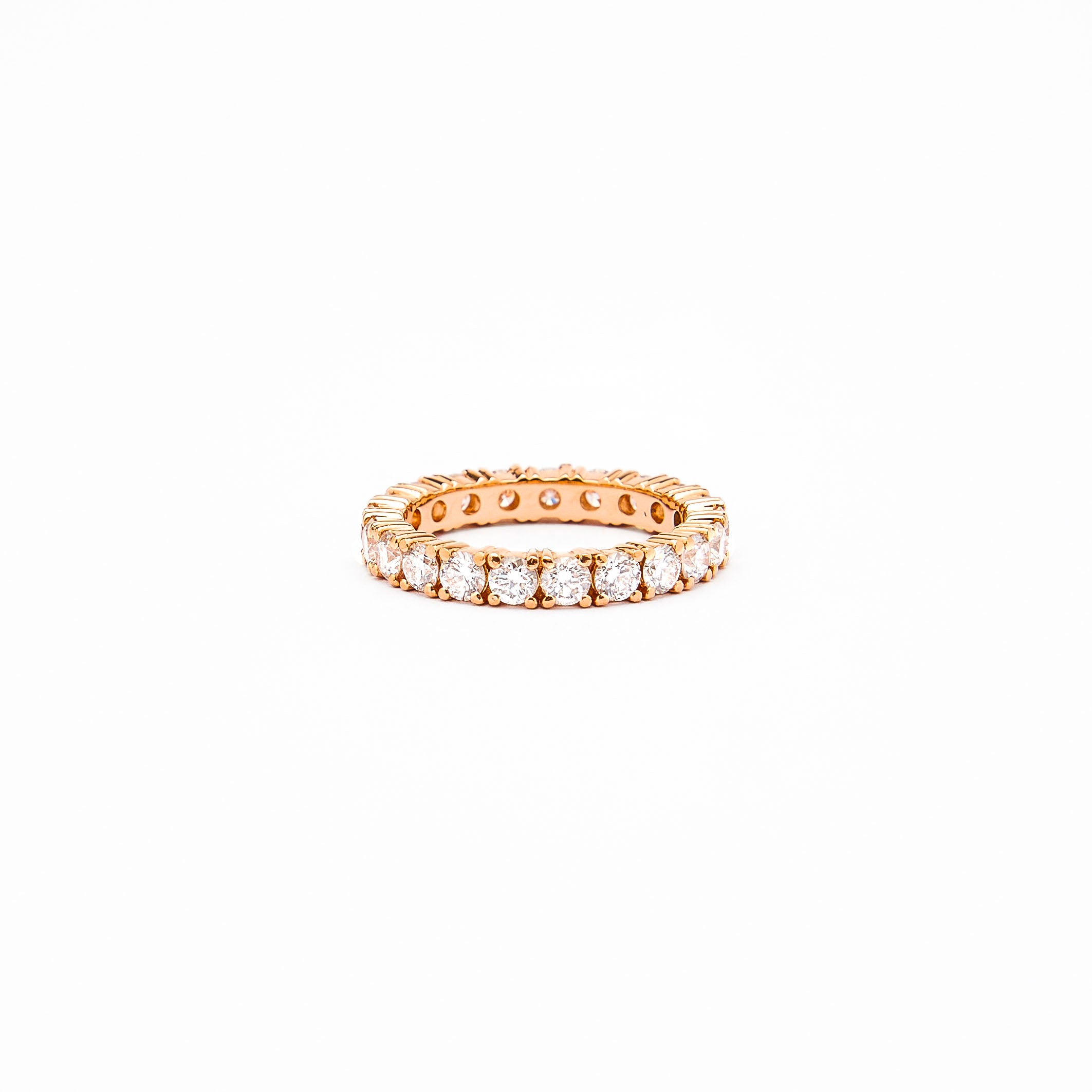 an 18k gold eternity ring with 3mm white diamonds on a white background.