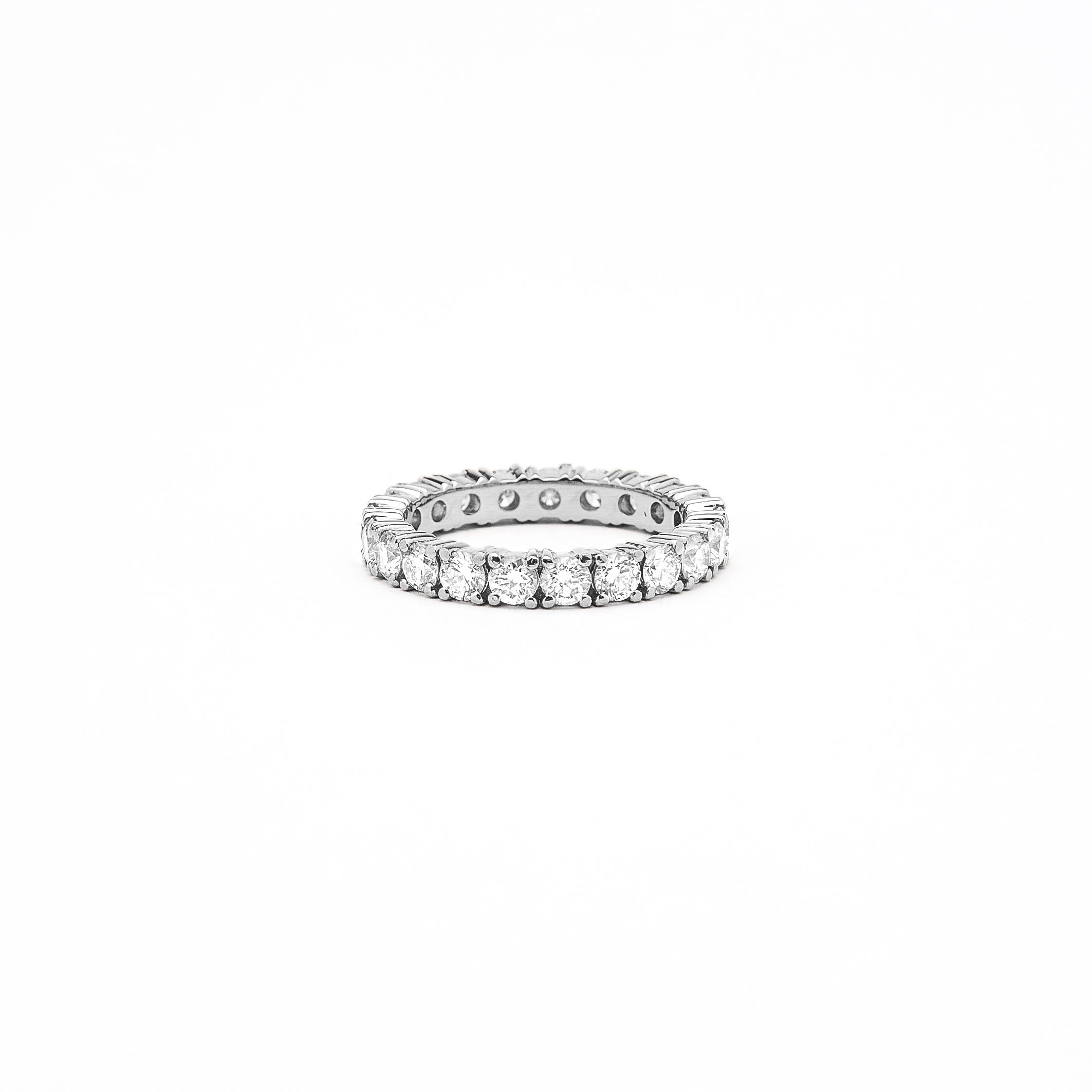 an 18k gold eternity ring with 3mm white diamonds on a white background.