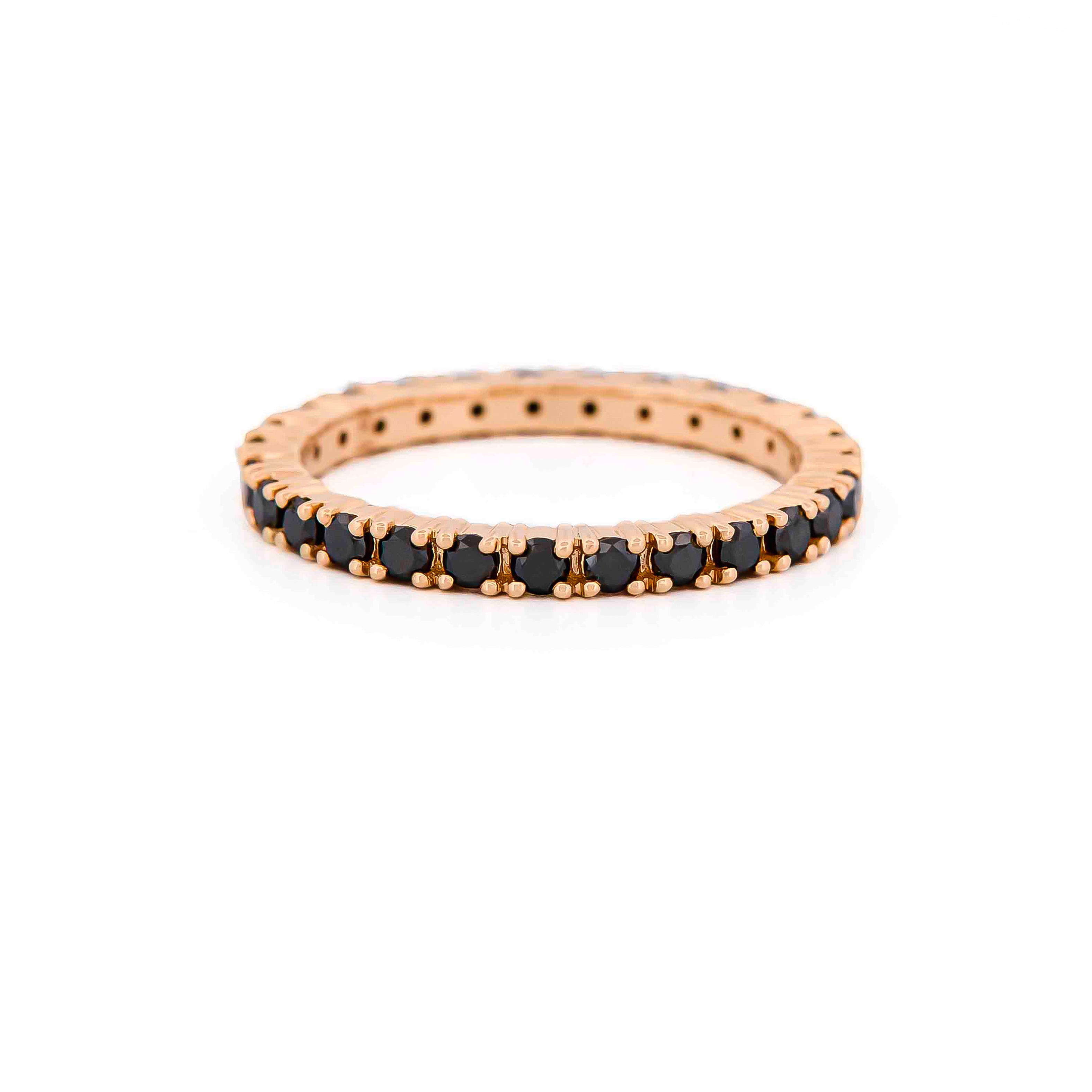 Rose gold eternity ring with black diamonds on a white background