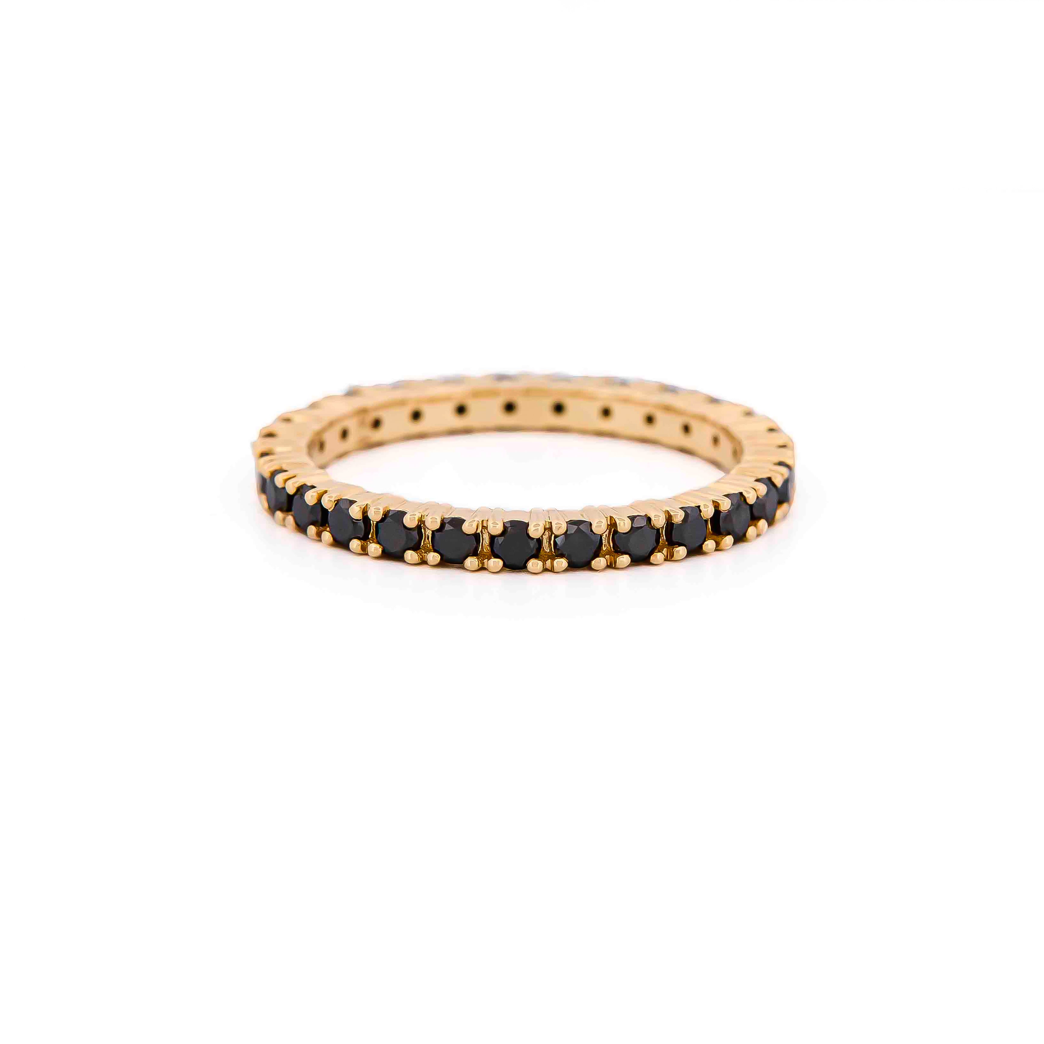 Gold eternity ring with black diamonds on a white background