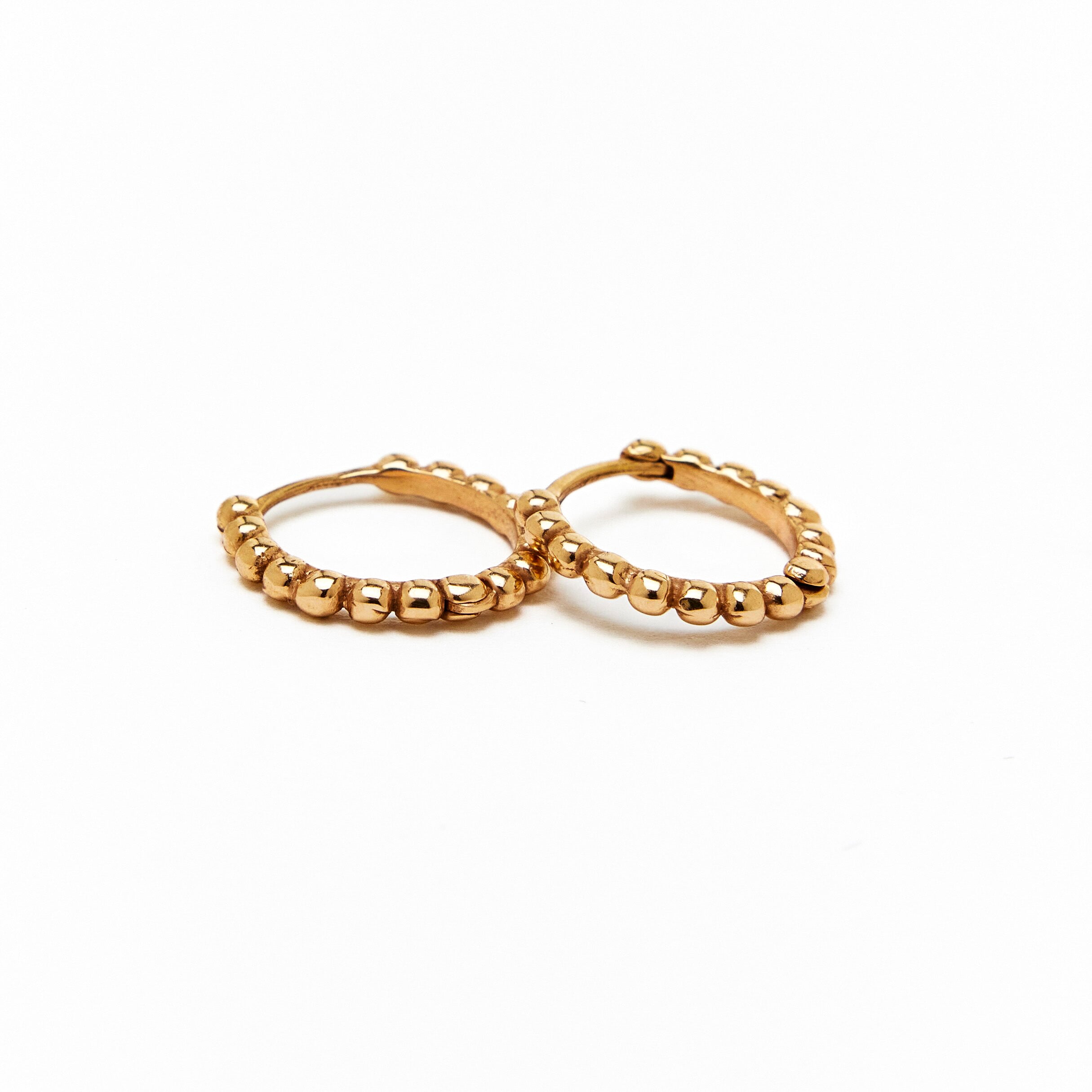 A pair of gold hoop earrings with a beaded design, made to order.