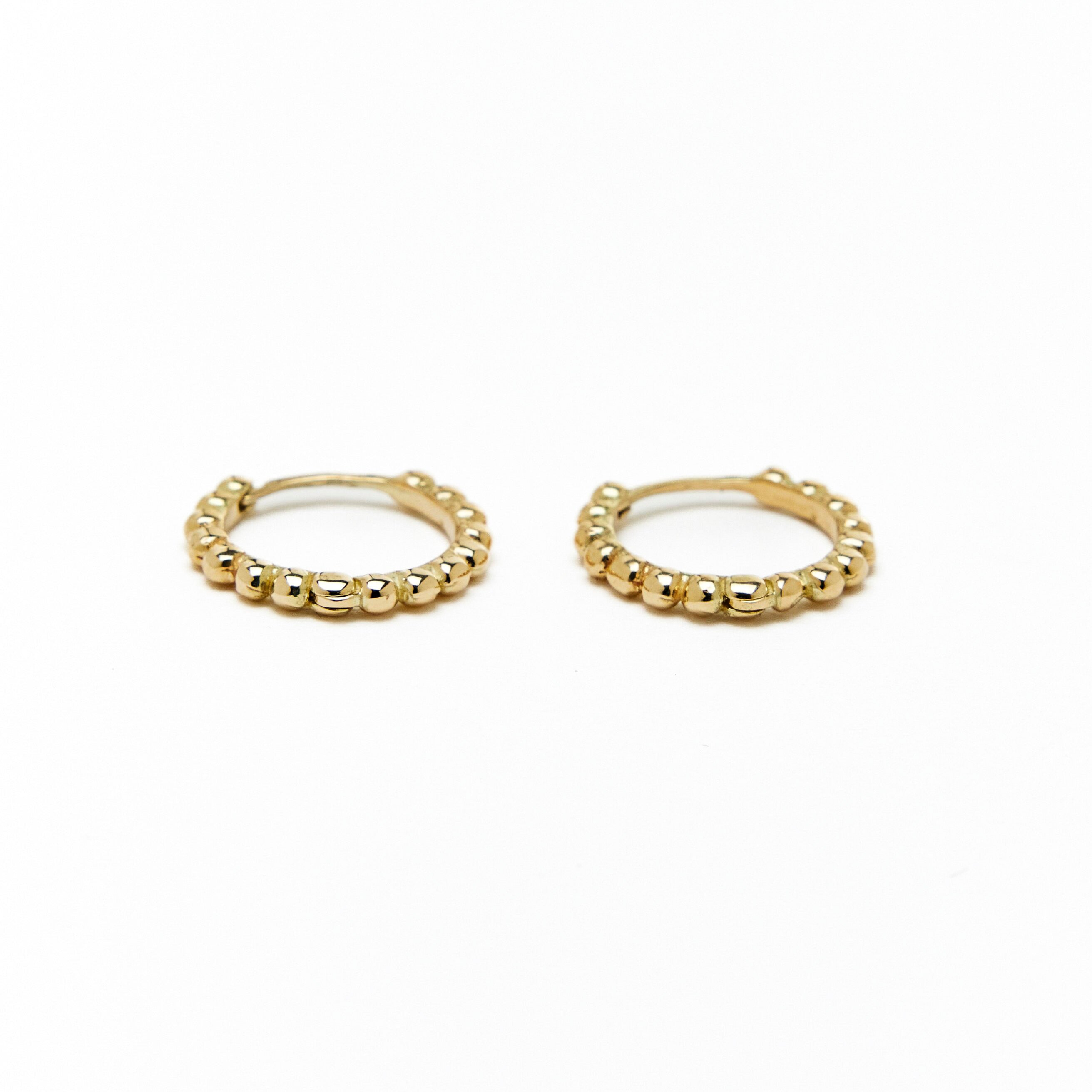 A pair of gold hoop earrings with a beaded design, made to order.