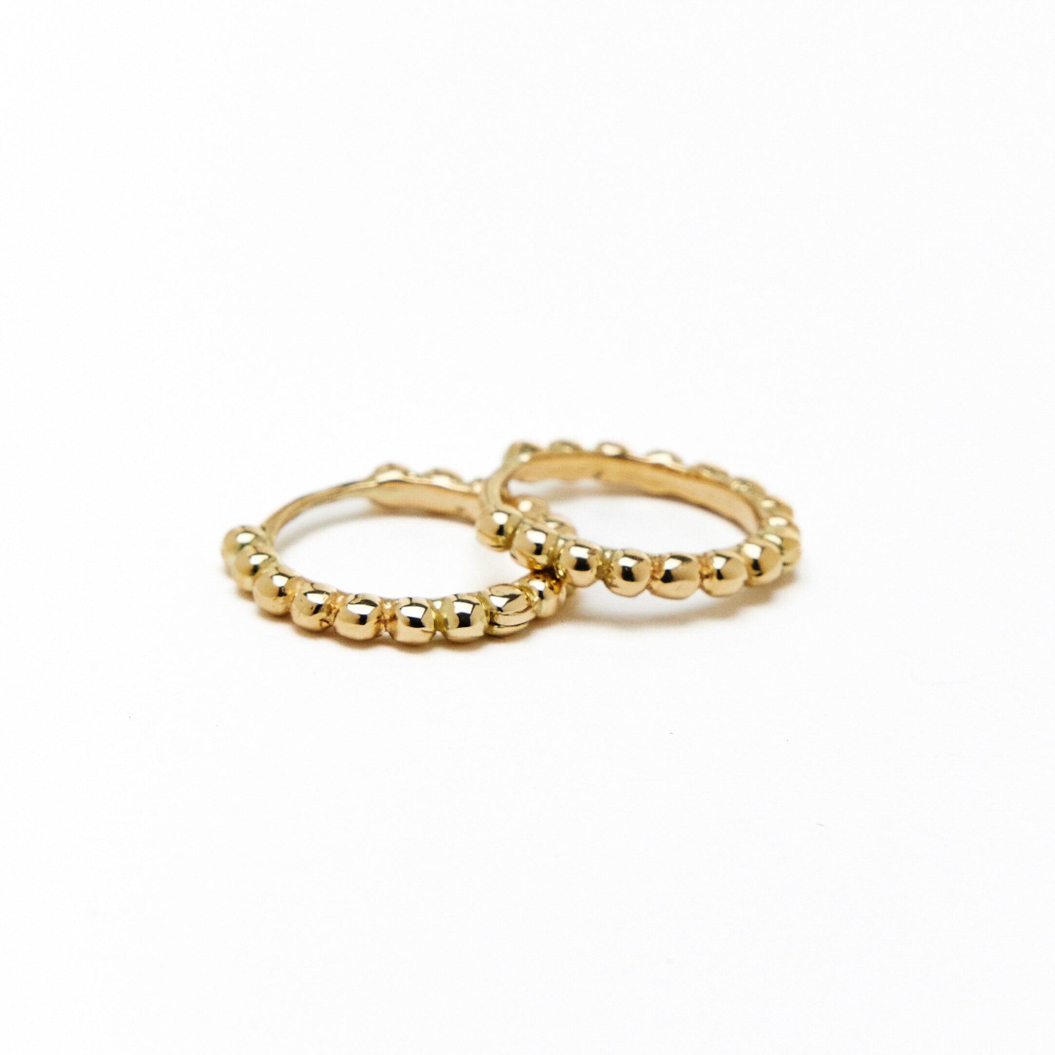 A pair of gold hoop earrings with a beaded design, made to order.