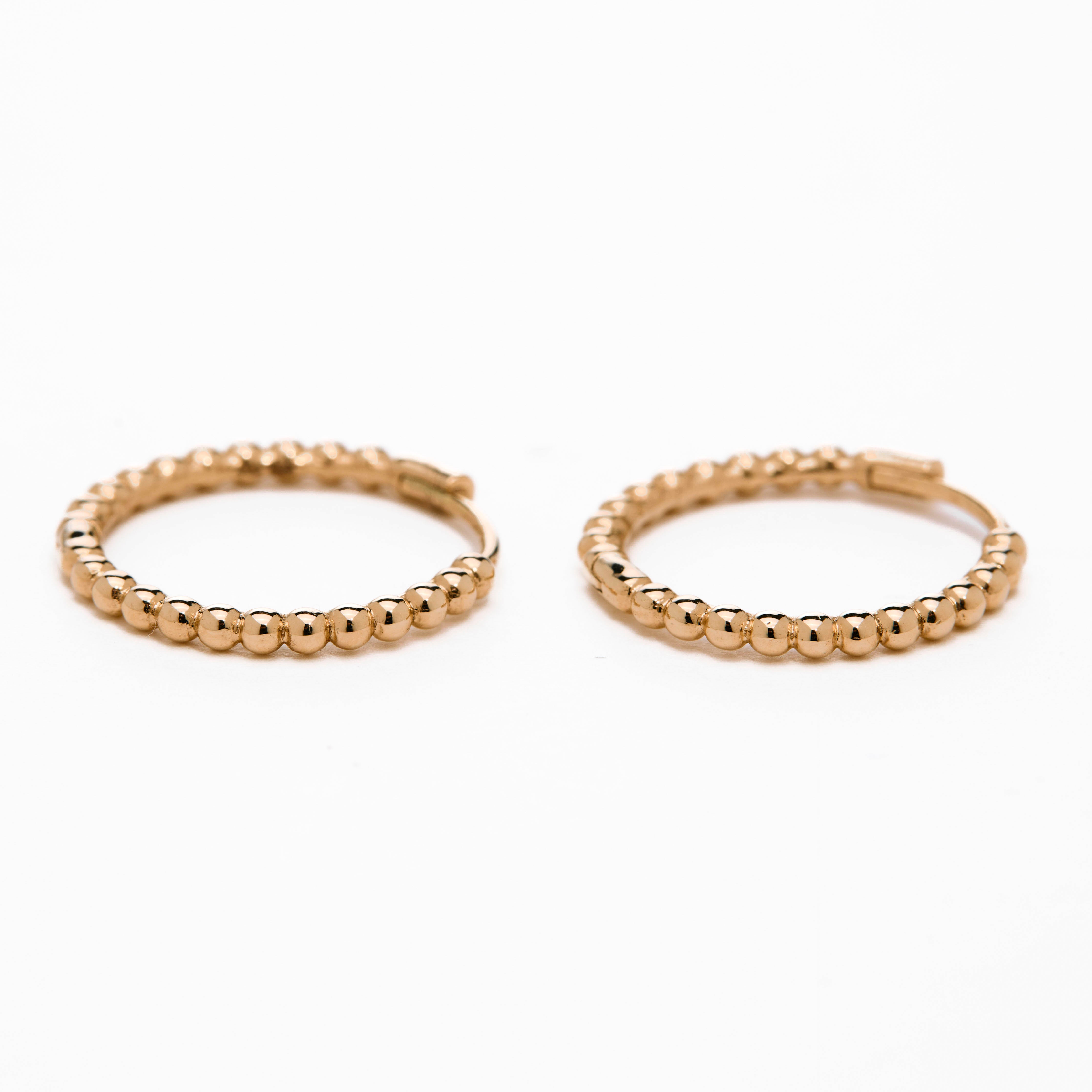 A pair of yellow  gold hoop earrings with a bubbly design, displayed against a white background.