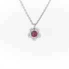 White gold necklace with a flower-shaped pendant featuring rubies and diamonds on a white background