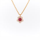 Yellow gold necklace with a flower-shaped pendant featuring rubies and diamonds on a white background