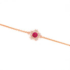 Rose gold bracelet with a ruby and diamonds flower on a white background