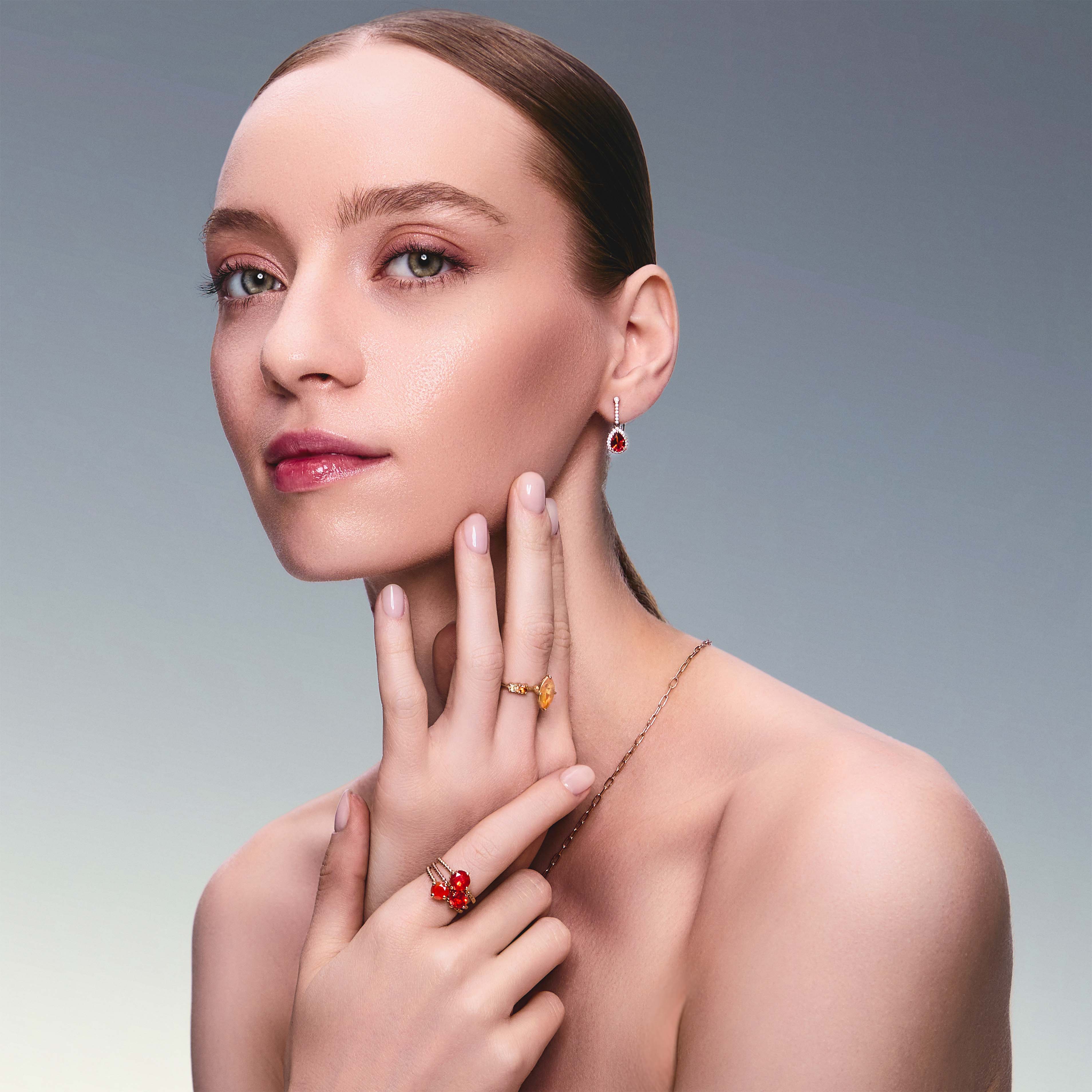 teardrop earring in red gold with diamonds and a teardrop fiery citrine on beautiful model. Also wearing mexican fire opal rings. 
