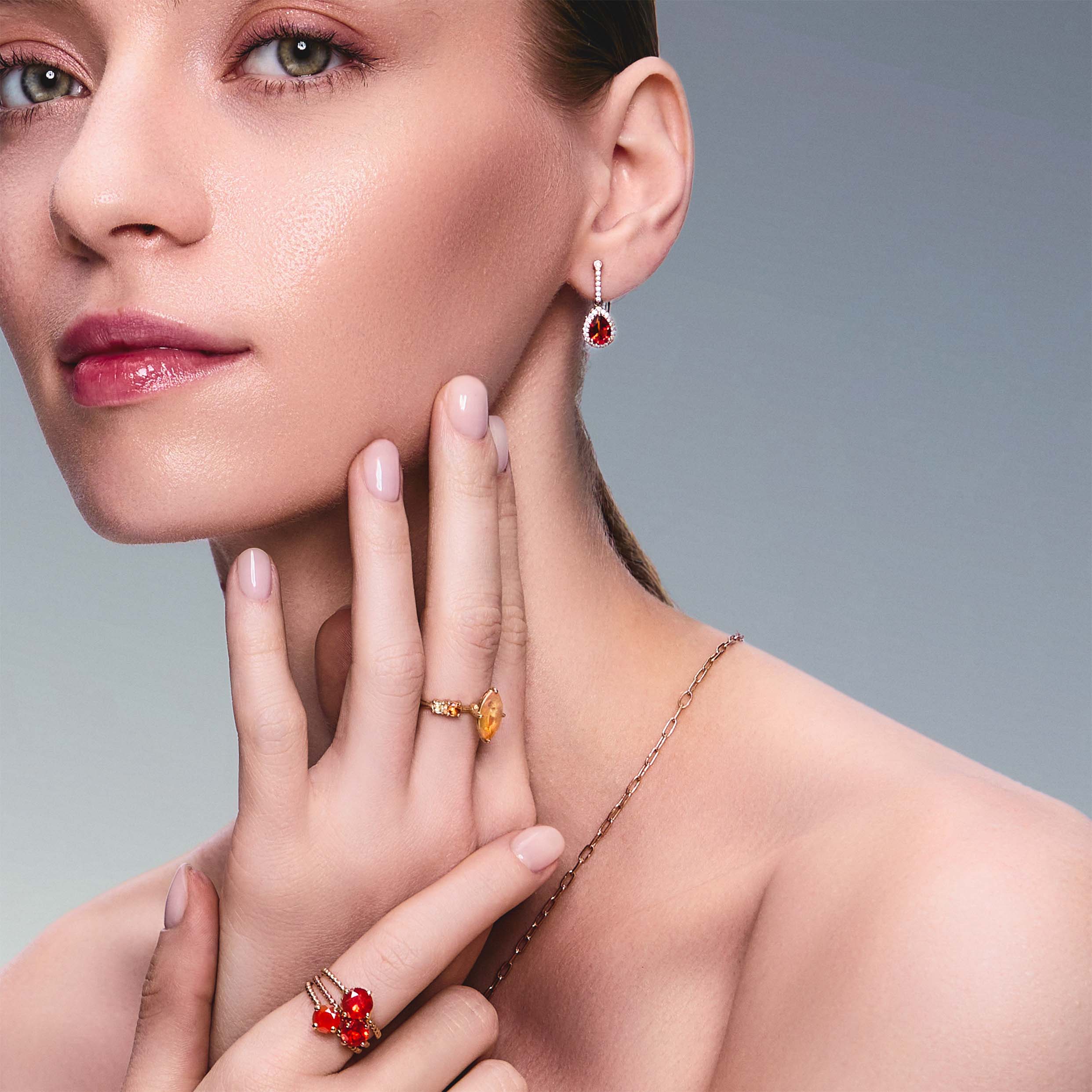 teardrop earring in red gold with diamonds and a teardrop fiery citrine on beautiful model. Also wearing mexican fire opal rings. 
