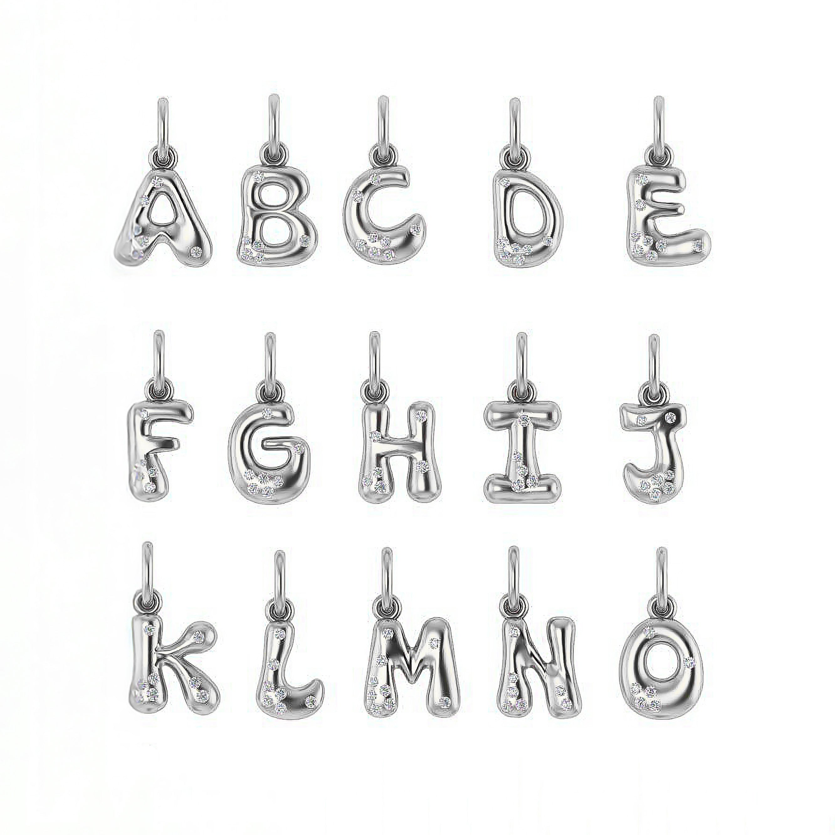 Gold letter pendants with sprinkled diamonds on a white background