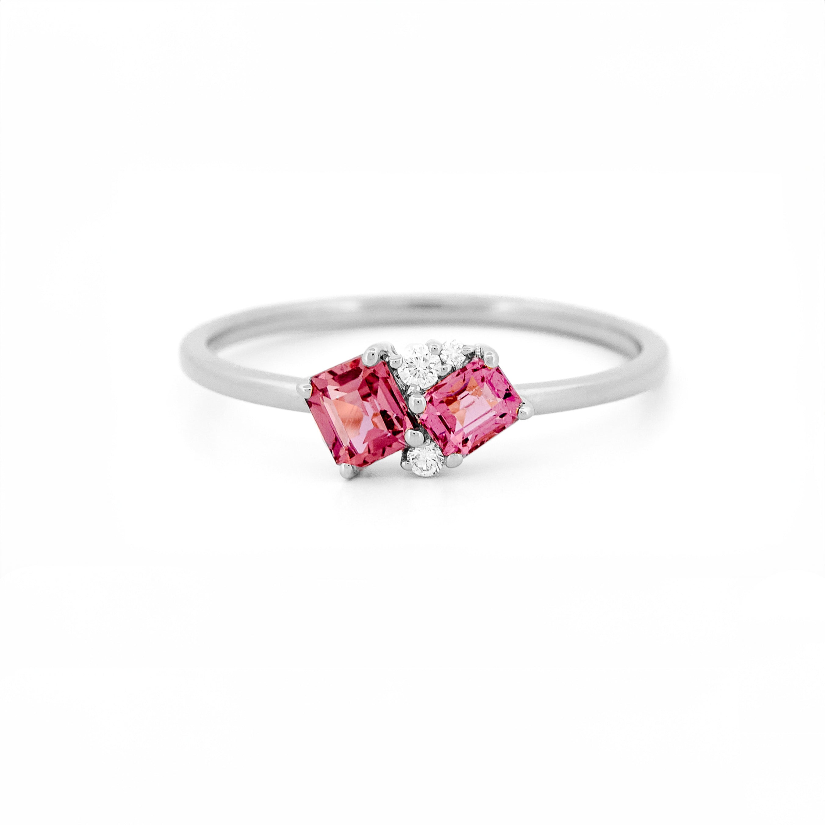 Gold ring with two pink sapphires and diamonds accents on a white background