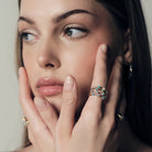 Woman wearing stackable Australian Opals and Diamonds Dew Drops Collection, with a visible Australian Opals, close-up of face and hand.