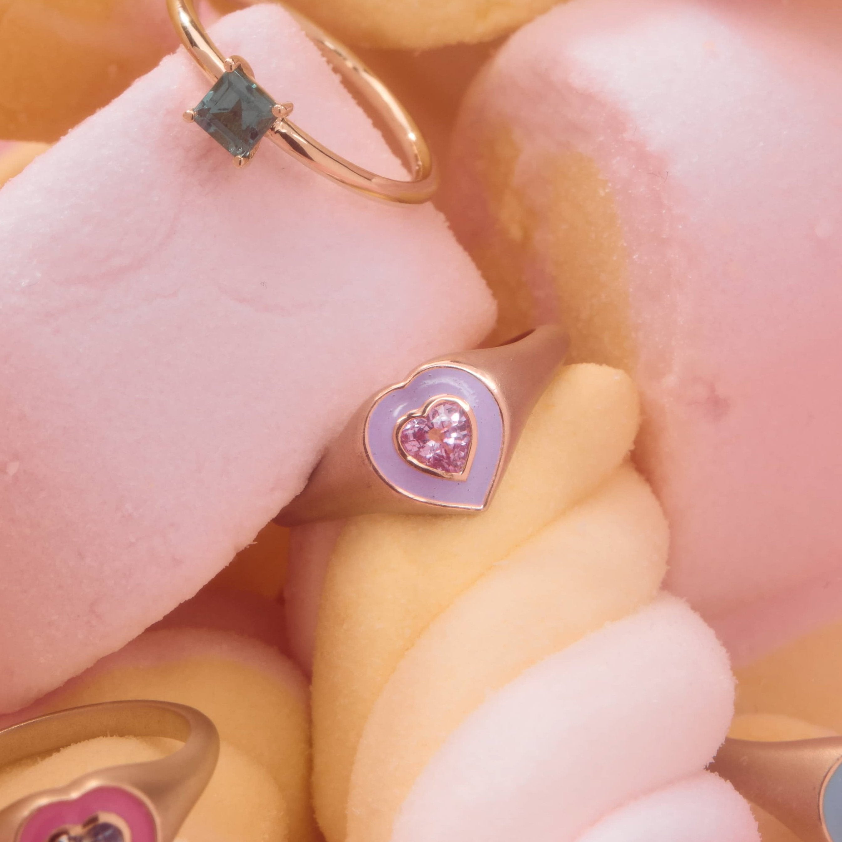 colorful enamel rings with sapphire accents in a bowl of candy