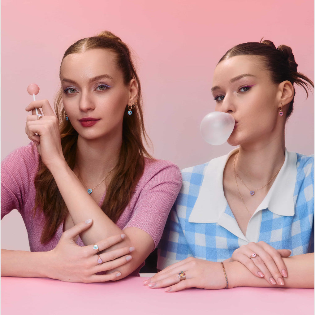 Two beautiful young girls wearing enamel and sapphire enamel jewelry, earrings, rings and pendants. One of the girls is also wearing stackable rings with rainbow sapphires and tourmalines