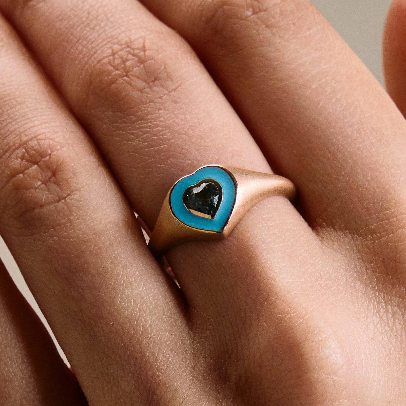  colorful enamel ring with sapphire green heart middle stone on hand