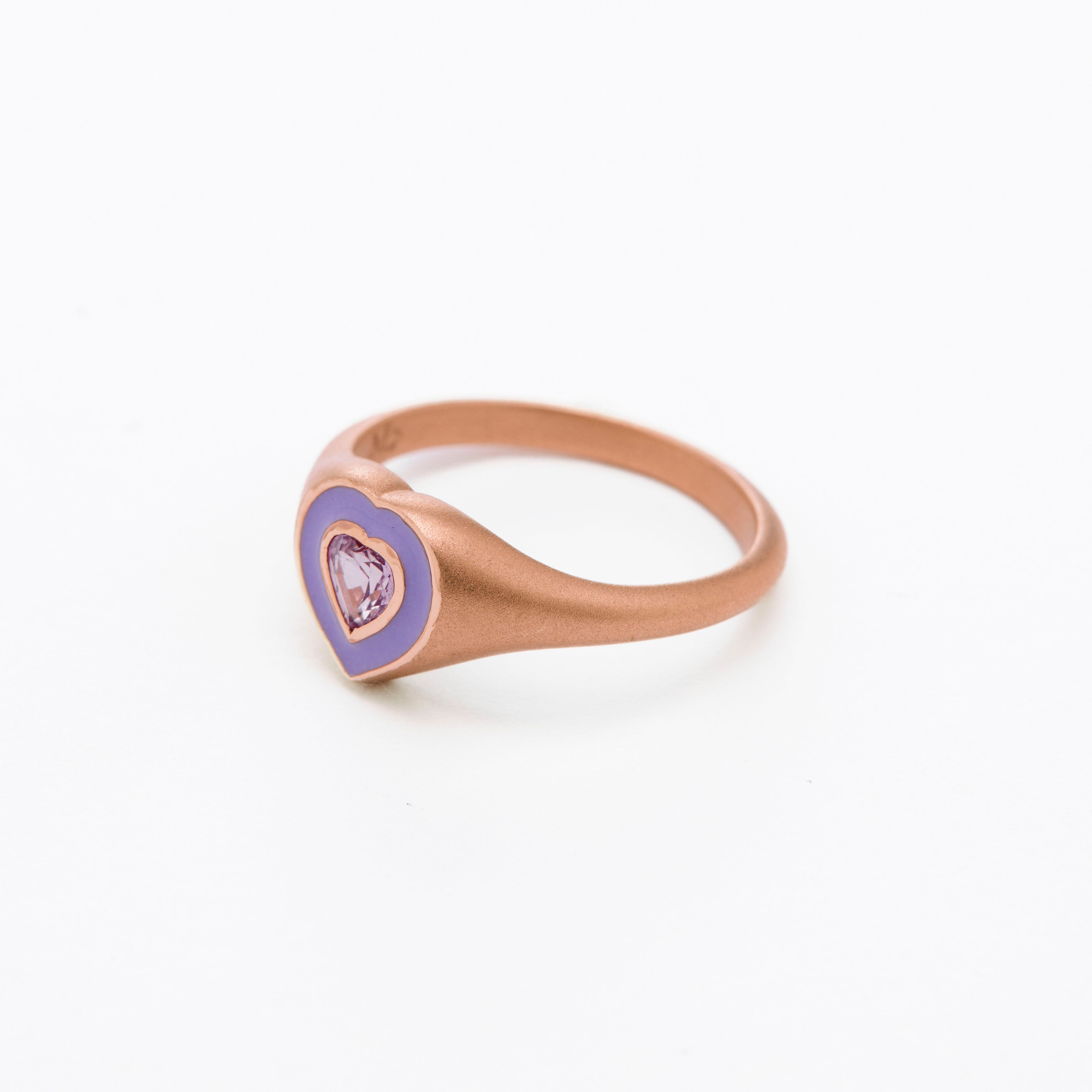 a colorful purple enamel ring with middle sapphire heart