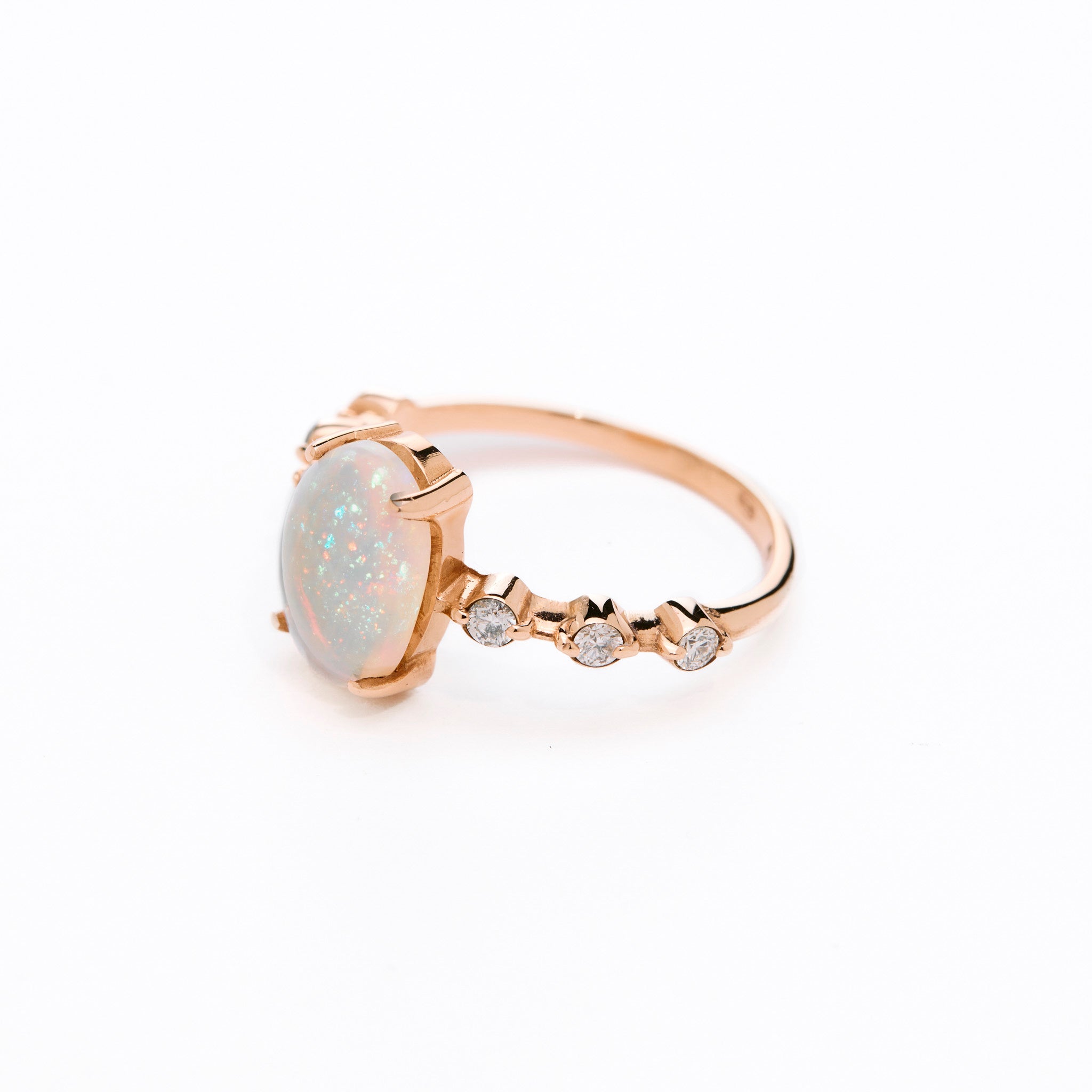 a gold ring with an opal center stone and white diamond accents on the band