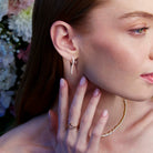 A beautiful diamond earring in the shape of an icicle on the ear.
Un cercel cu diamante spectaculos în formă de țurțure văzut pe ureche.