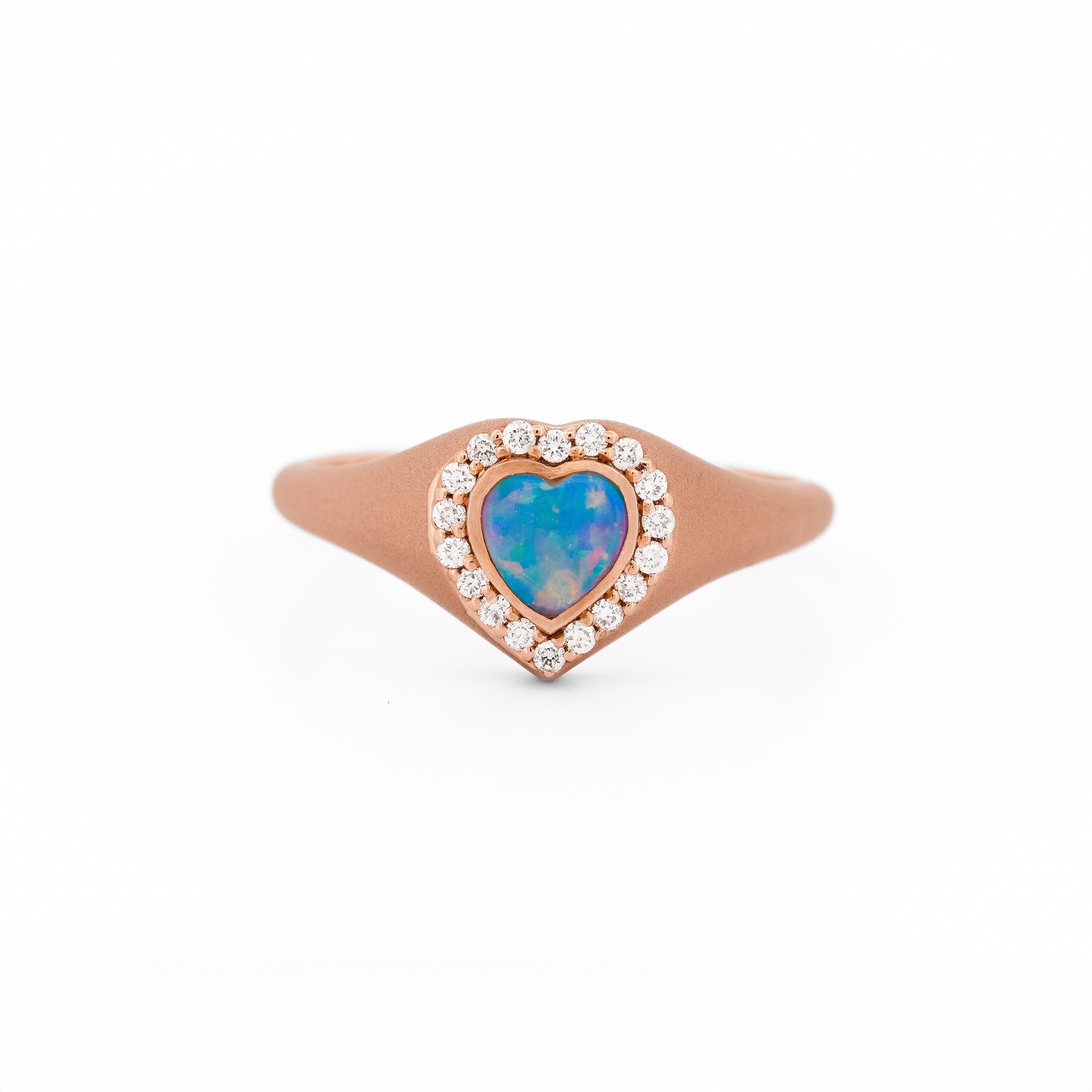 Heart-shaped opal signet ring with rose gold and diamonds on a white background