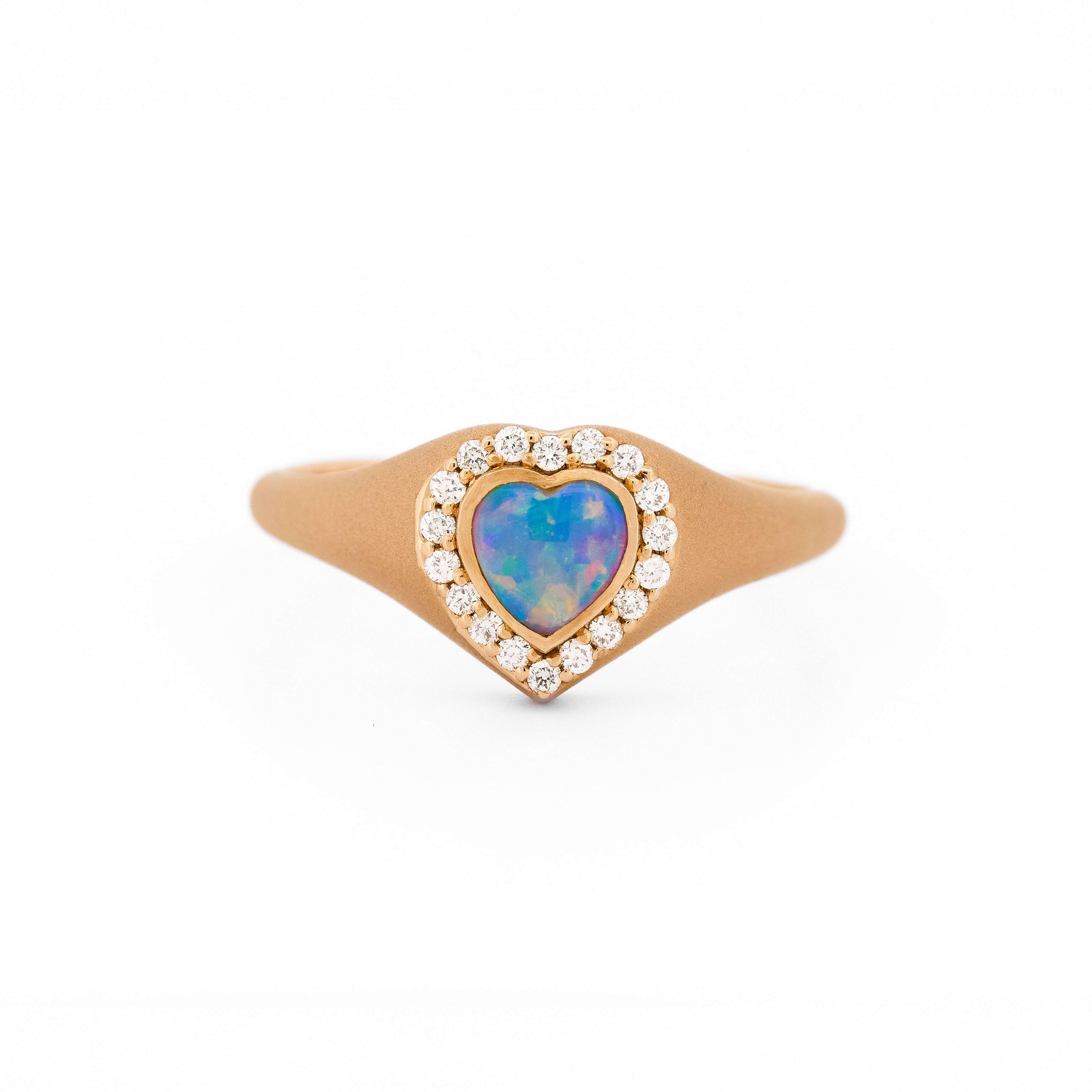 Heart-shaped australian opal signet ring with rose gold and diamonds on a white background