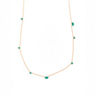 Necklace with emeralds gemstones on a white background