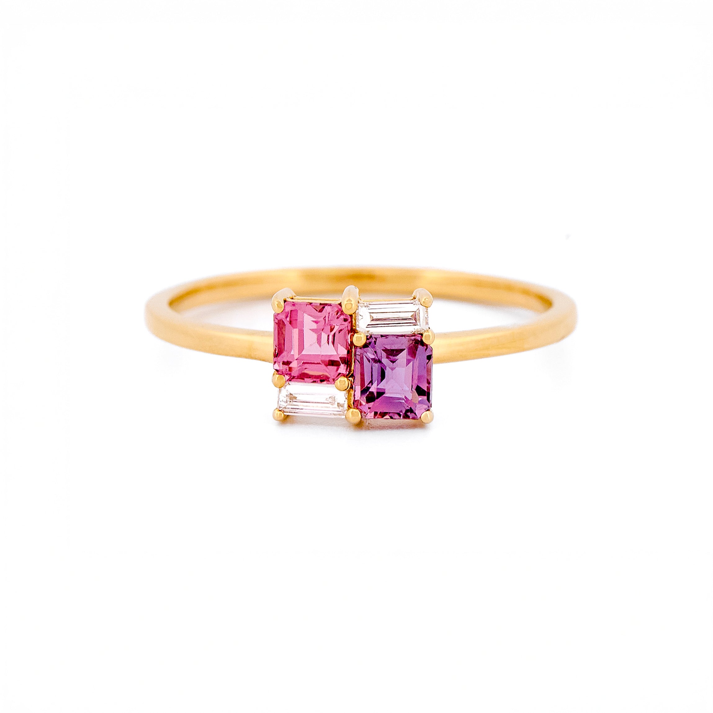 Gold ring with two pink sapphires and two diamonds on a white background.