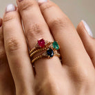 elegant oval blue sapphire ring, oval ruby ring and oval emerald ring with diamonds side cluster and a twisted band stacked on hand 