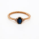 elegant oval blue sapphire ring with diamonds side cluster and a twisted band 