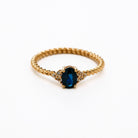 elegant oval blue sapphire ring with diamonds side cluster and a twisted band 