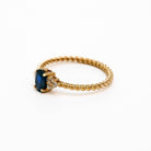 elegant oval blue sapphire ring with diamonds side cluster and a twisted band 