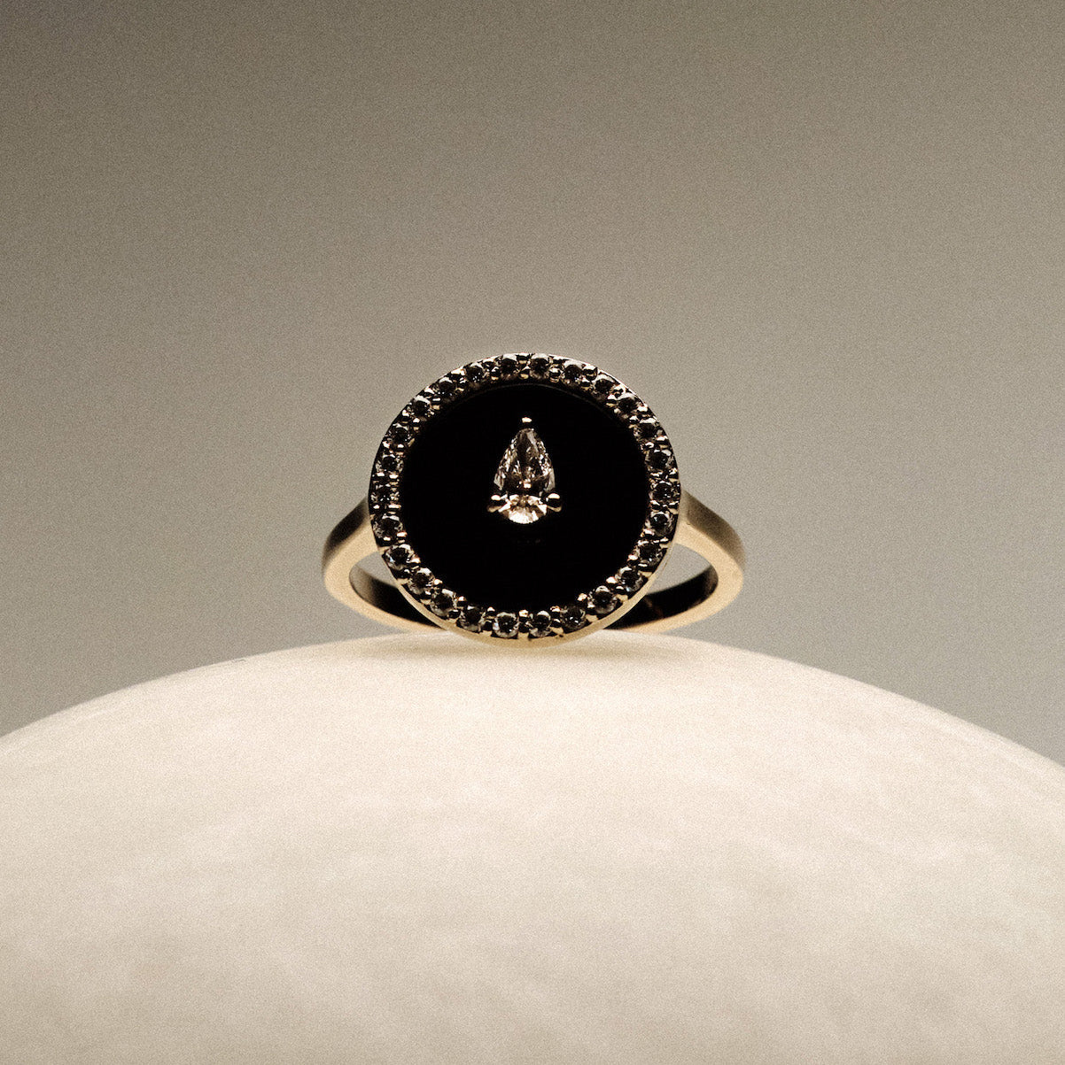 Black Onyx and diamonds Gold Ring on a round marble.