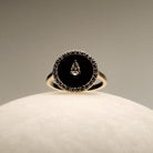 Black Onyx and diamonds Gold Ring on a round marble.