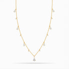 Yellow Gold necklace with teardrop and round diamond pendants on a white background