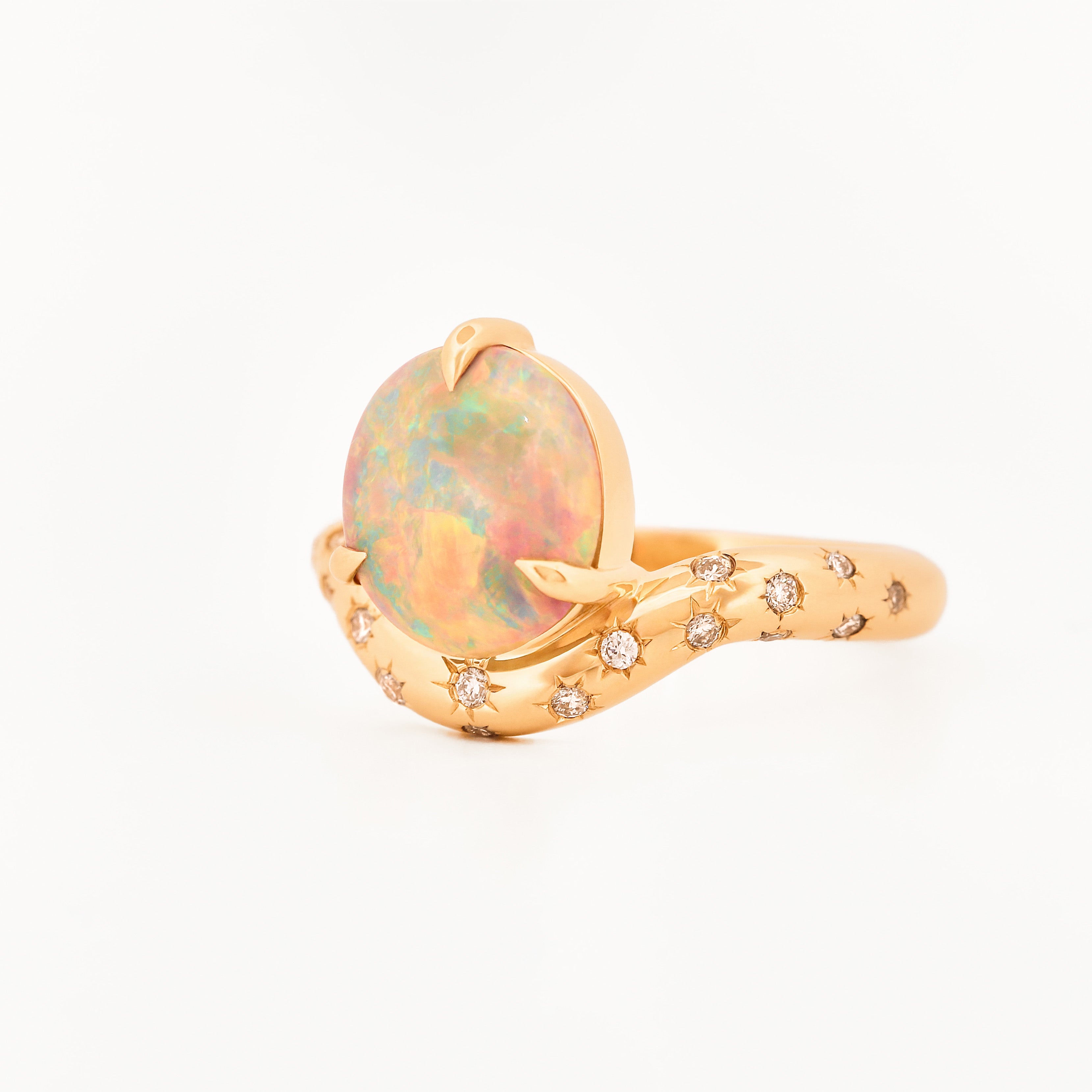 Yellow Gold ring with an australian opal centrestone on a white background.