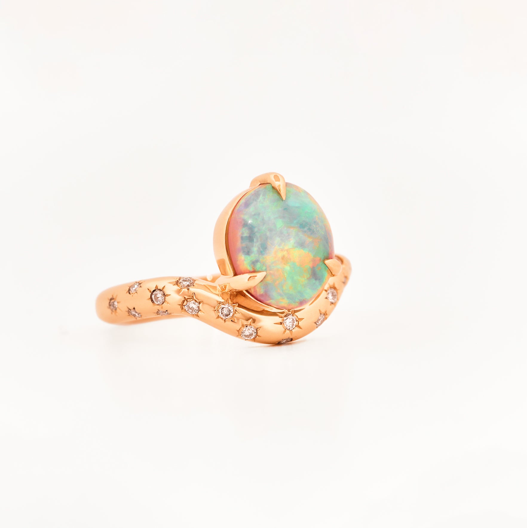 Rose Gold ring with an australian opal centrestone on a white background.