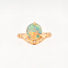Yellow Gold ring with an australian opal centrestone on a white background.
