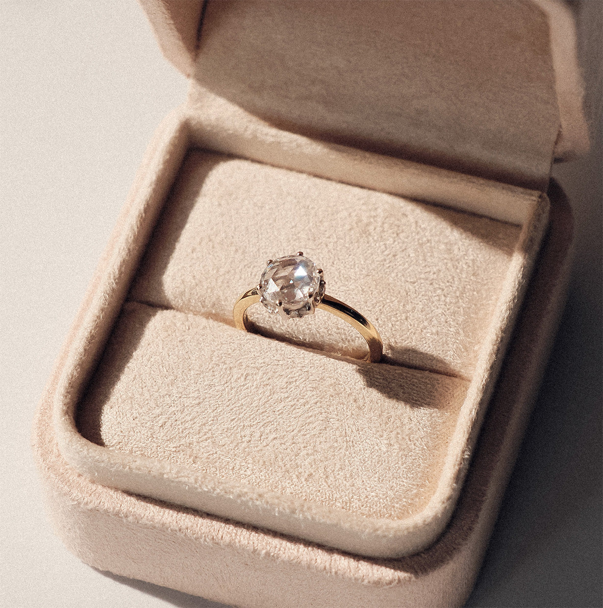 Rose cut Diamond ring in a beige jewelry box on a neutral background