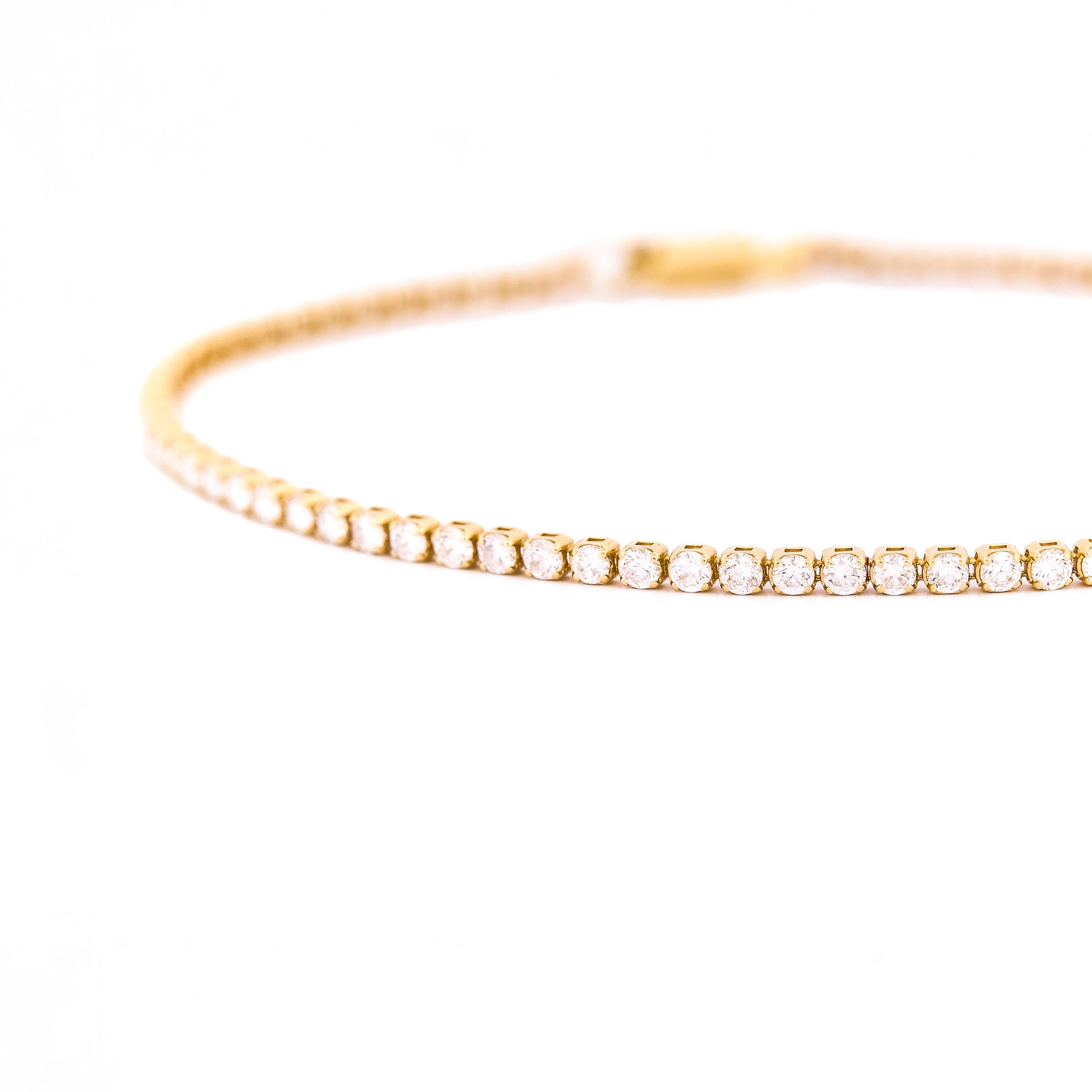 Gold diamonds tennis bracelet on a white background.