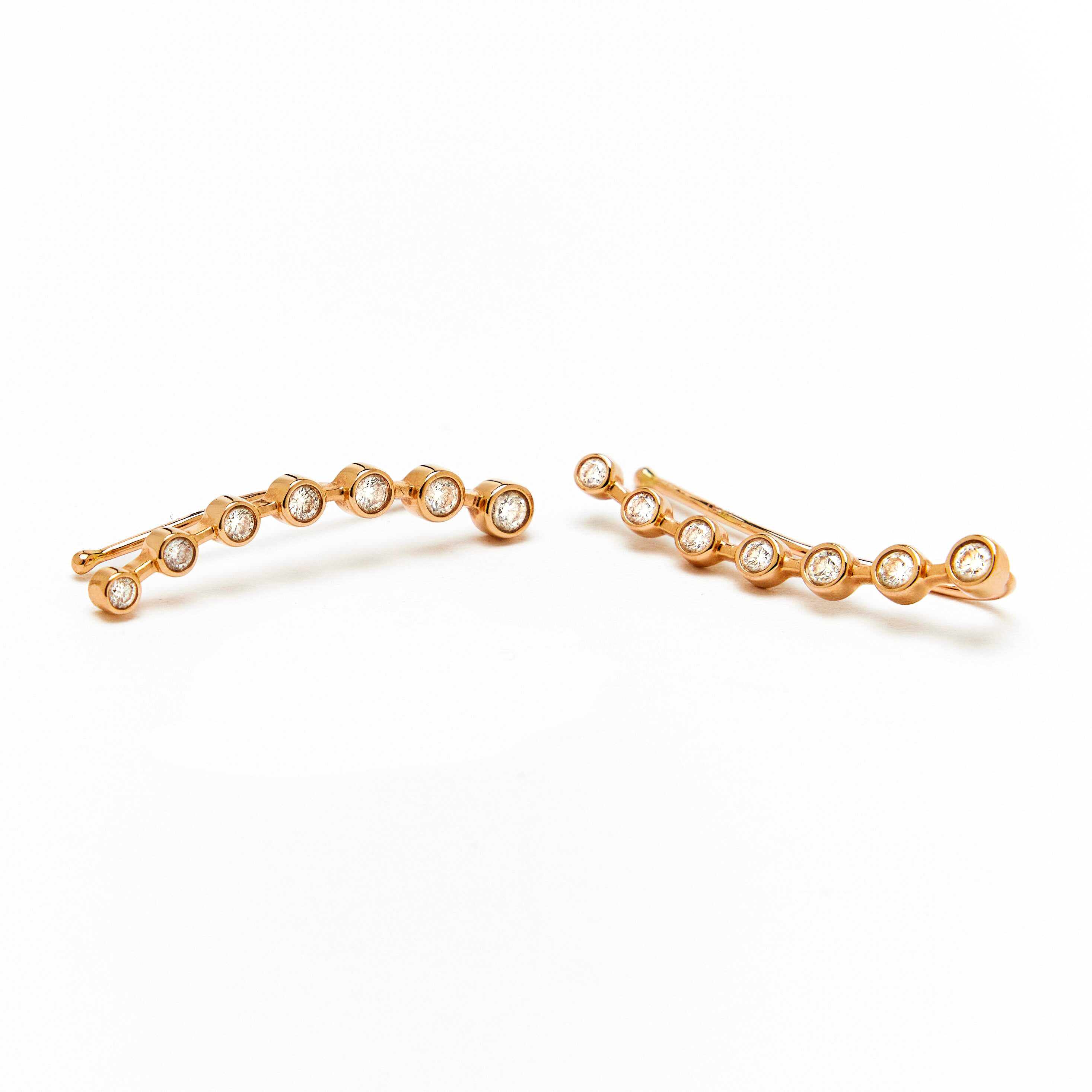 gold ear-crawler earrings adorned with white diamonds.