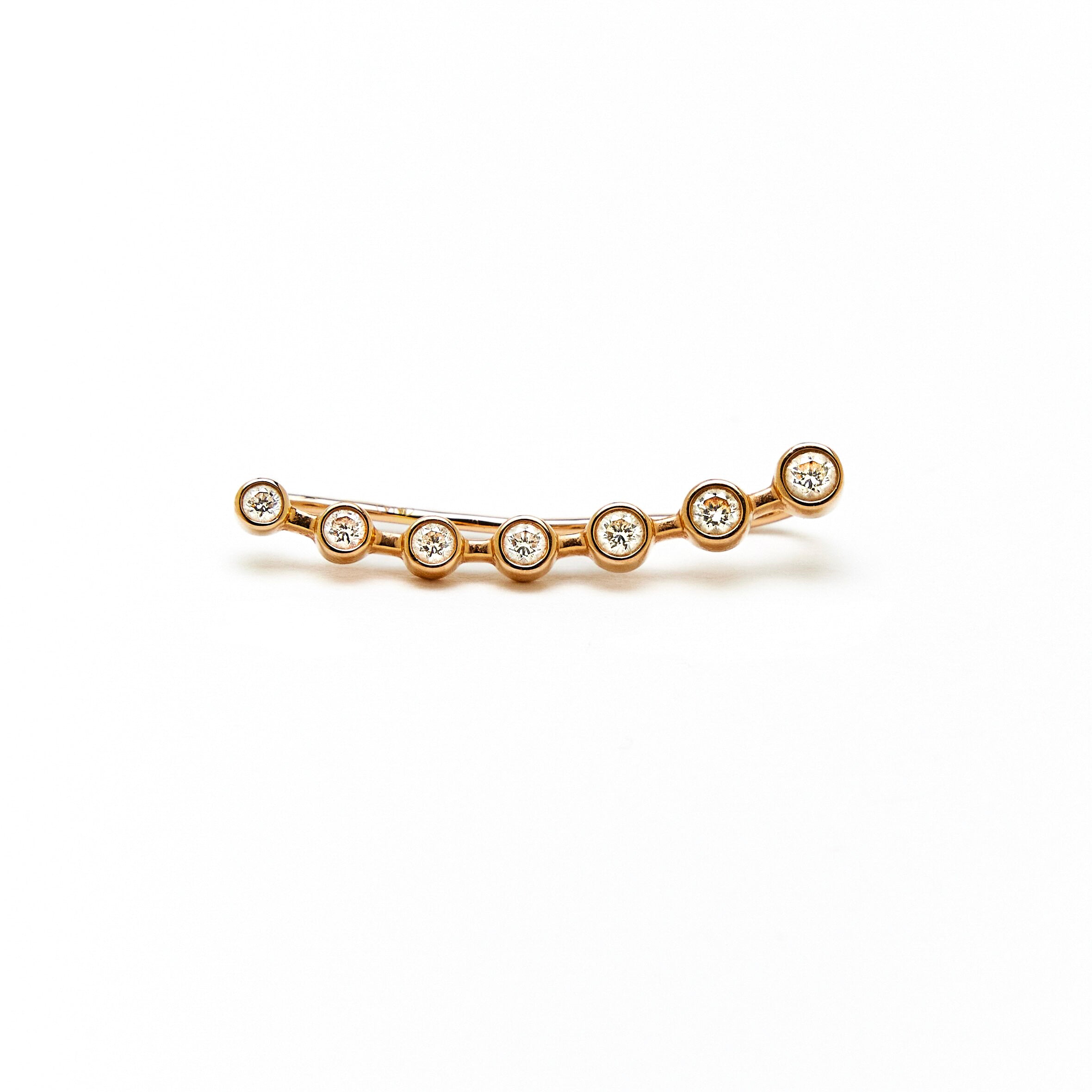 a gold ear-crawler earring adorned with white diamonds.